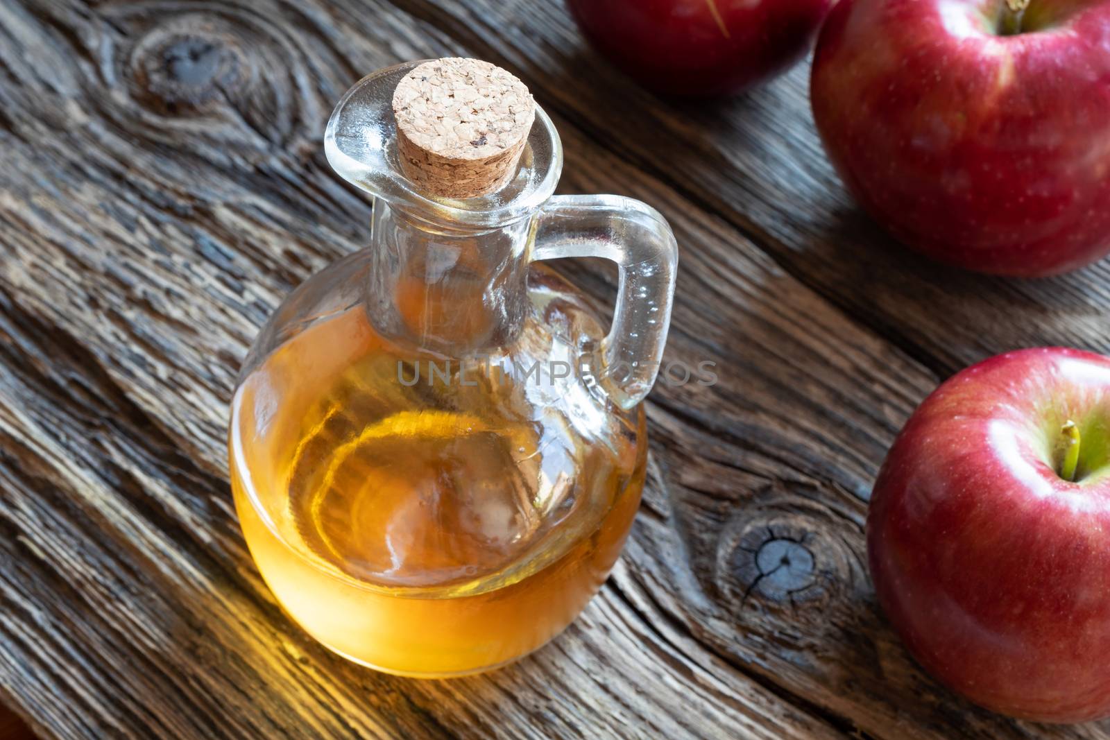 A bottle of apple cider vinegar on a rustic background