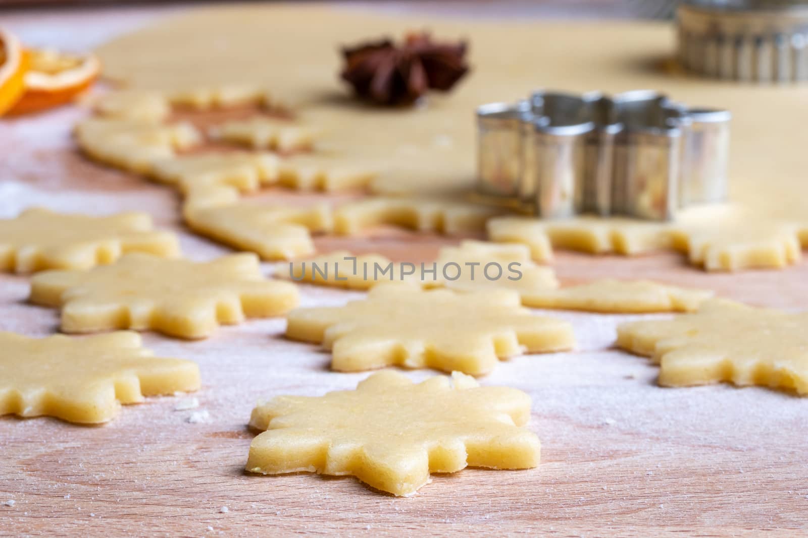 Cutting out shapes from rolled out dough to prepare traditional Linzer Christmas cookies