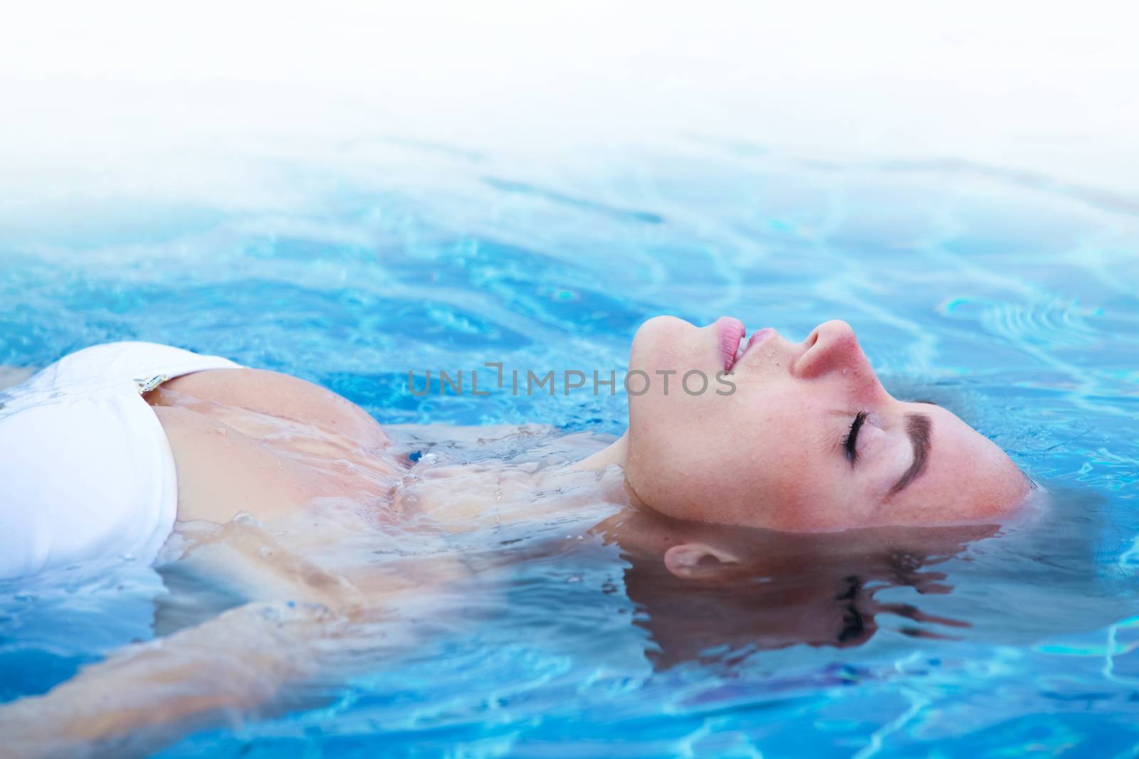 Girl relaxing in swimming pool by Yellowj