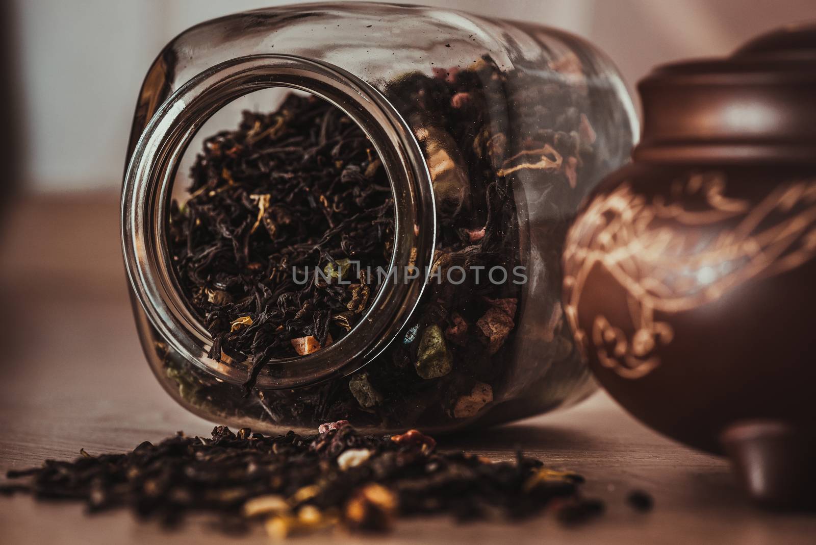 Asian teapot on stand and jar with scattering of tea by Seva_blsv