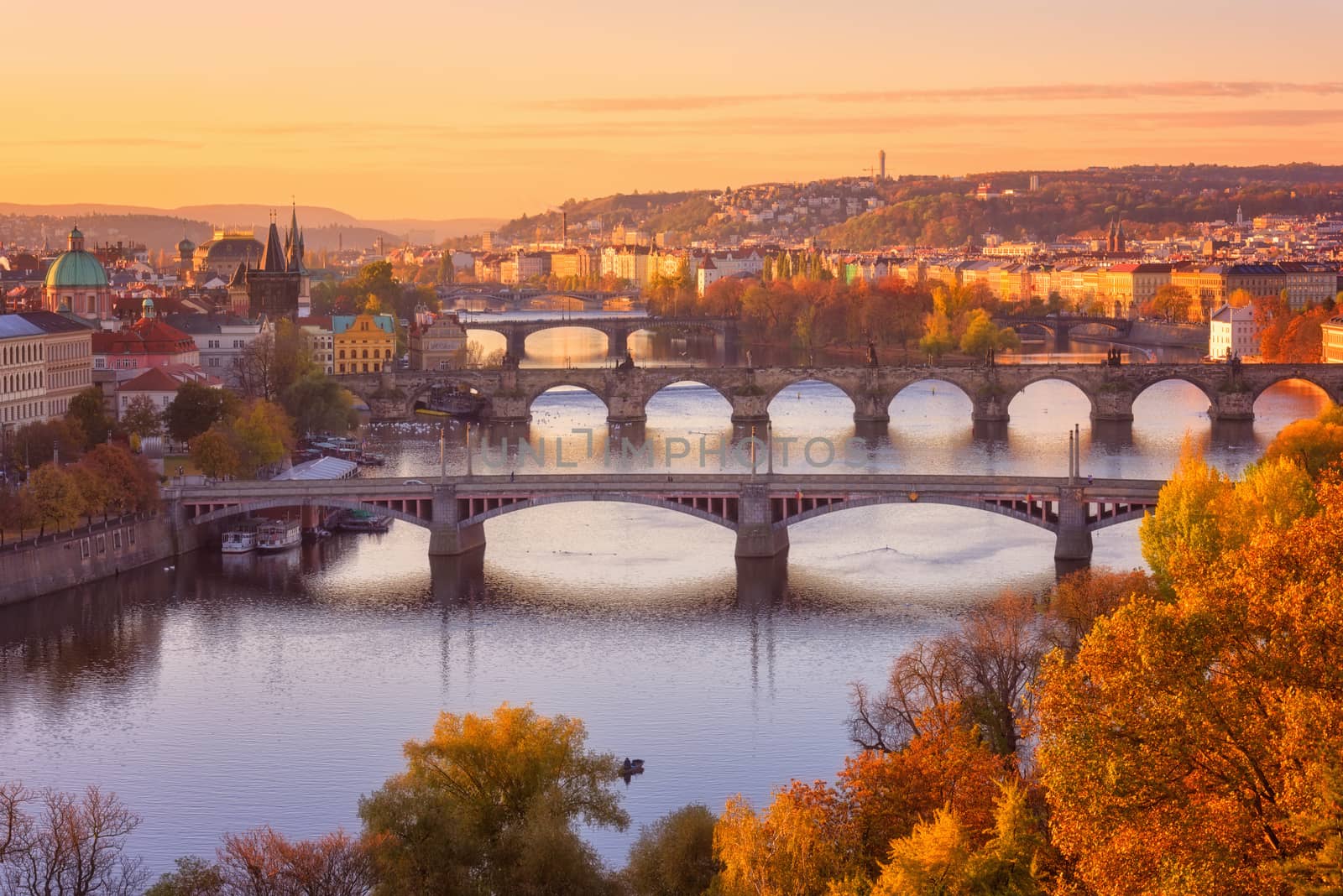 View to the historical bridges, Prague old town and Vltava river from popular view point in the Letna park (Letenske sady), beautiful autumn landscape in soft sunset light with amazing colorful cloudy sky, Czech Republic