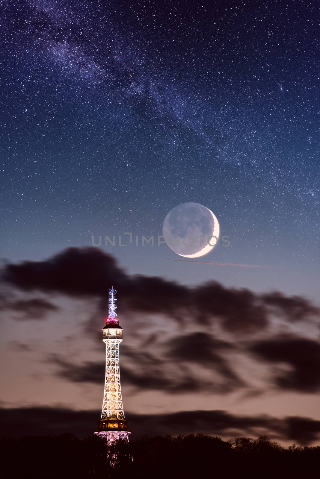 Petrin lookout tower (Petrinska rozhledna) in Prague, night landscape with new moon and fantastic starry sky and milky way, Czech Republic