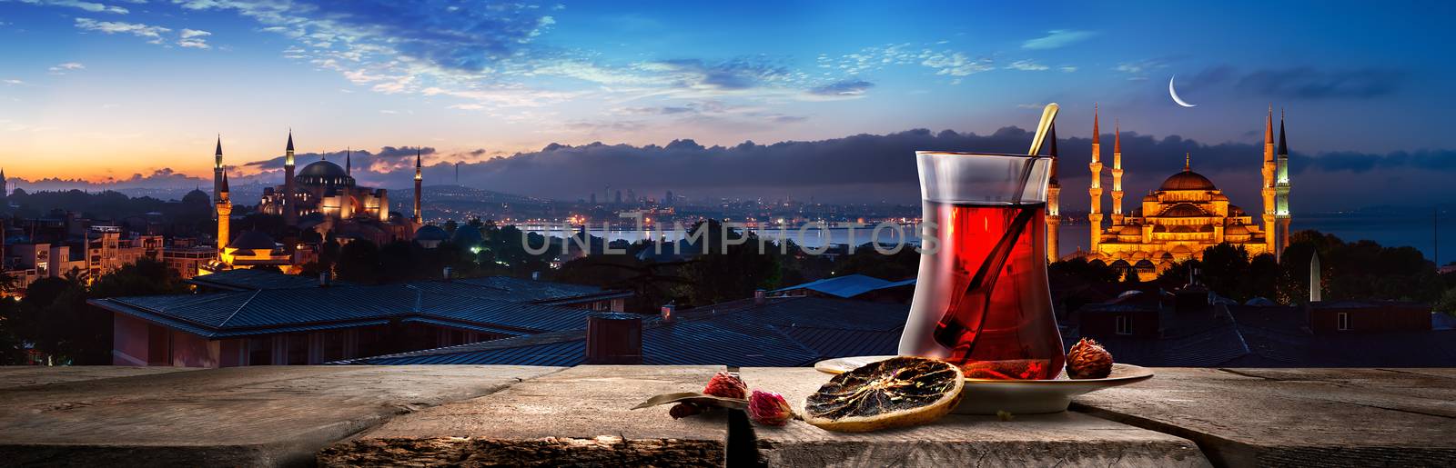 Tea and panorama of Istanbul with the view on Blue Mosque and Hagia Sophia near Bosphorus at sunset, Turkey