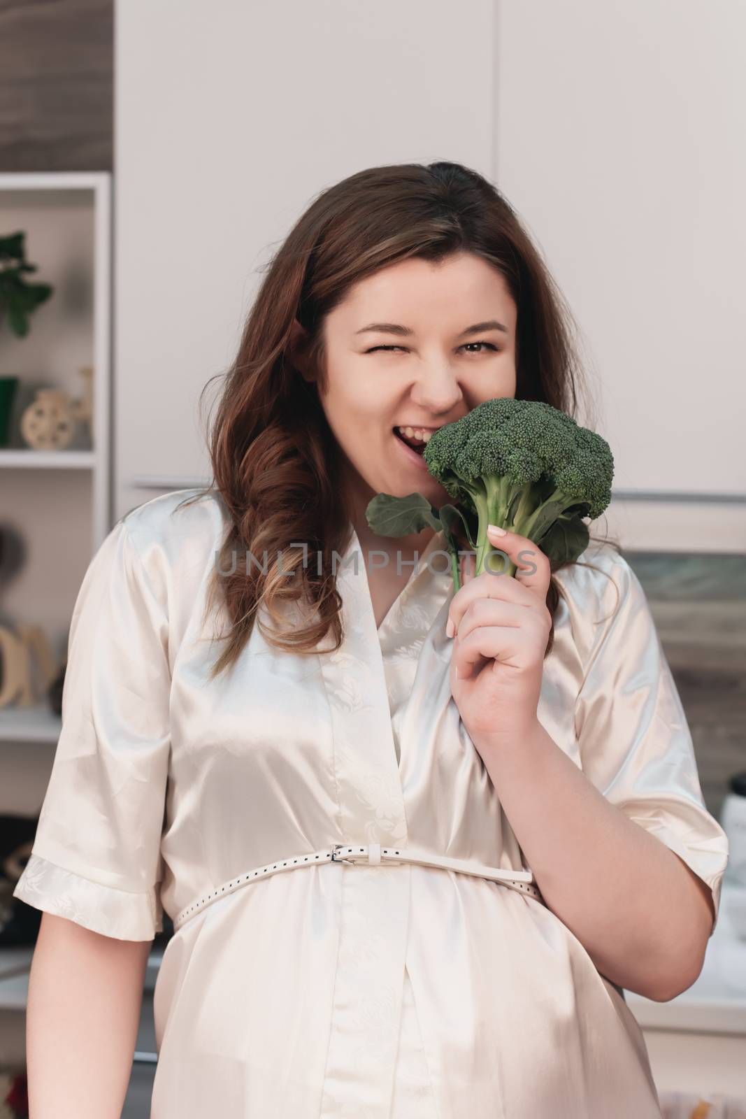 portrait of a happy pregnant woman in the kitchen with healthy food