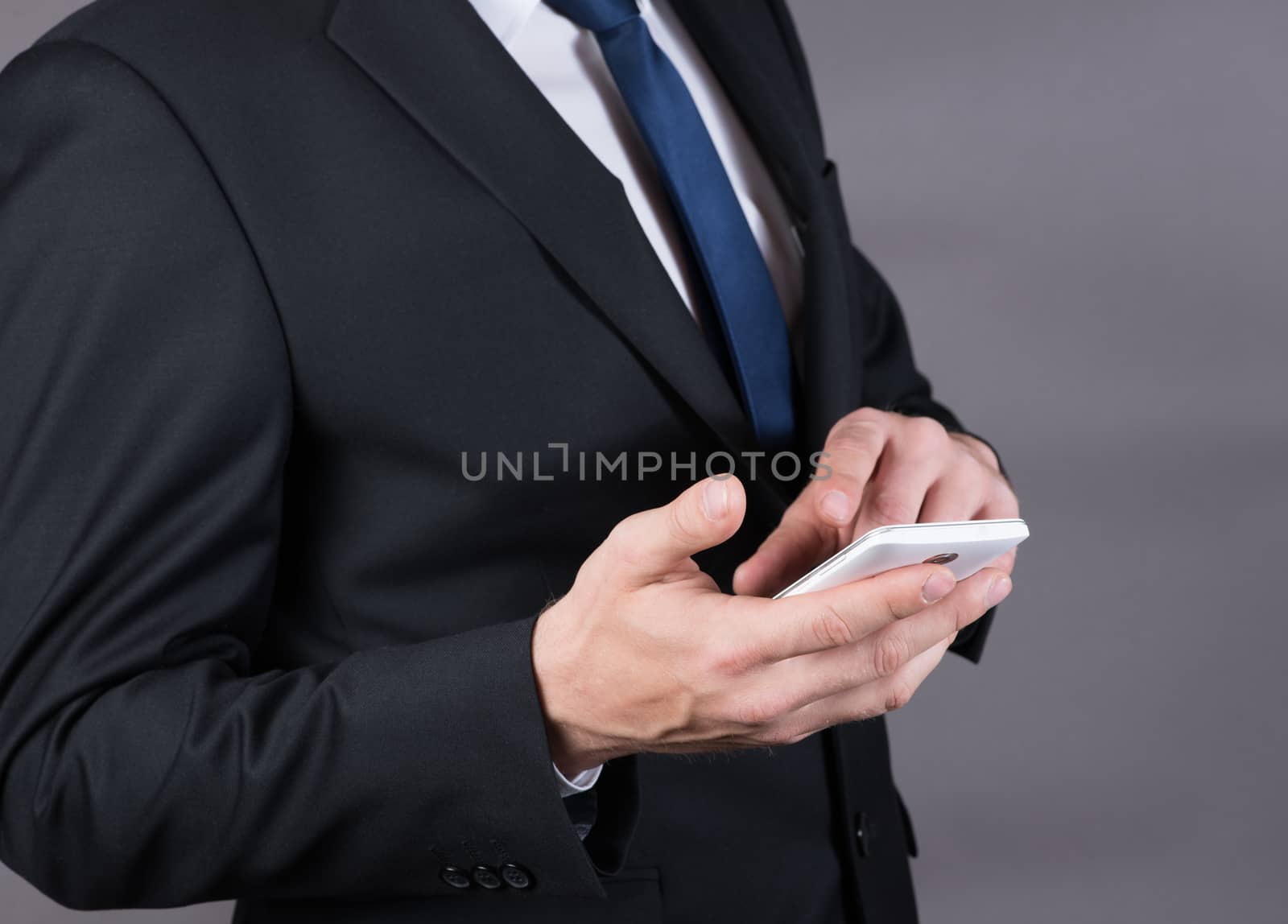 Closeup of a successful businessman using mobile smart phone by claire_lucia