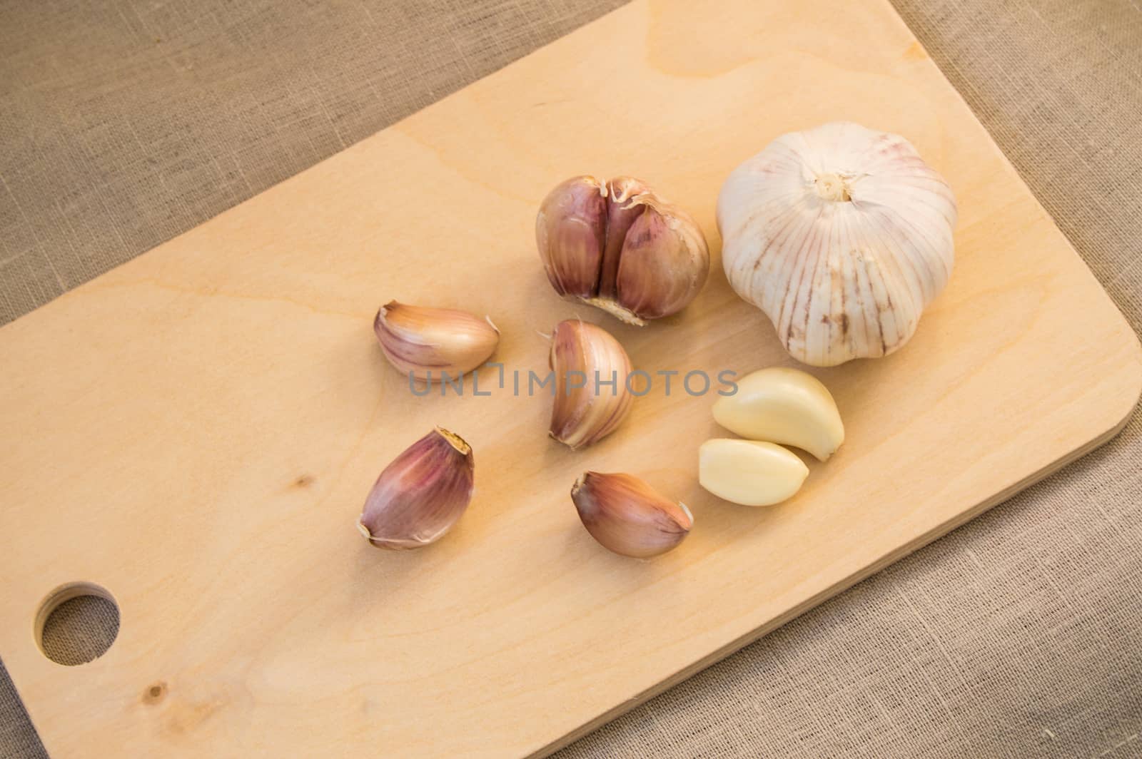 Cloves and clove of garlic on wooden cutting Board by claire_lucia