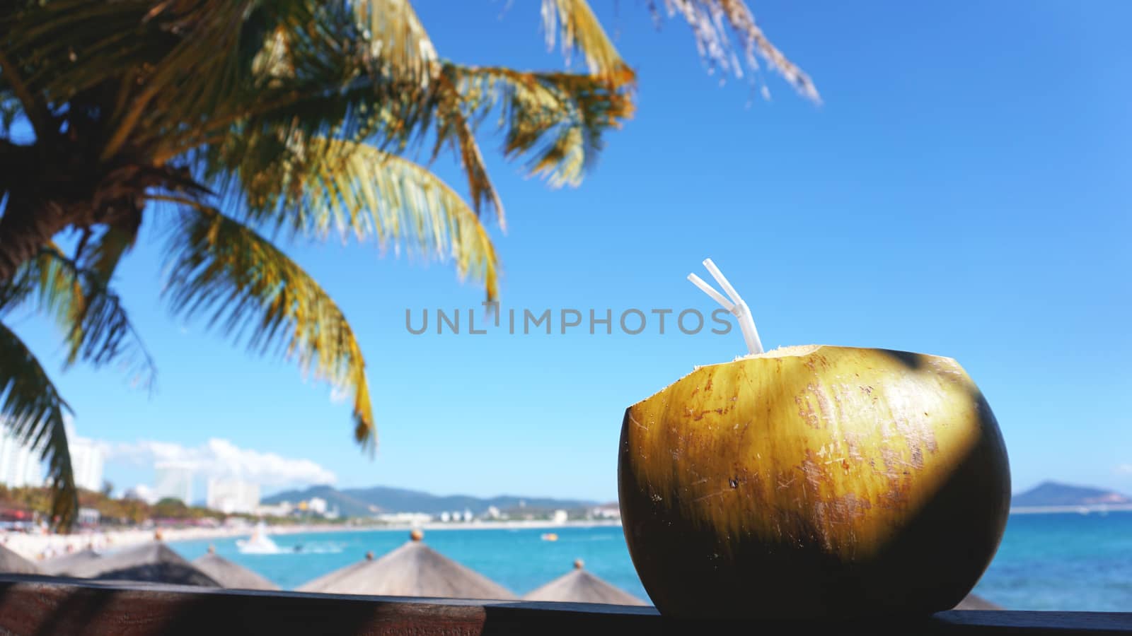 Coconut water drink on a tropical beach. Sea Beach in the background