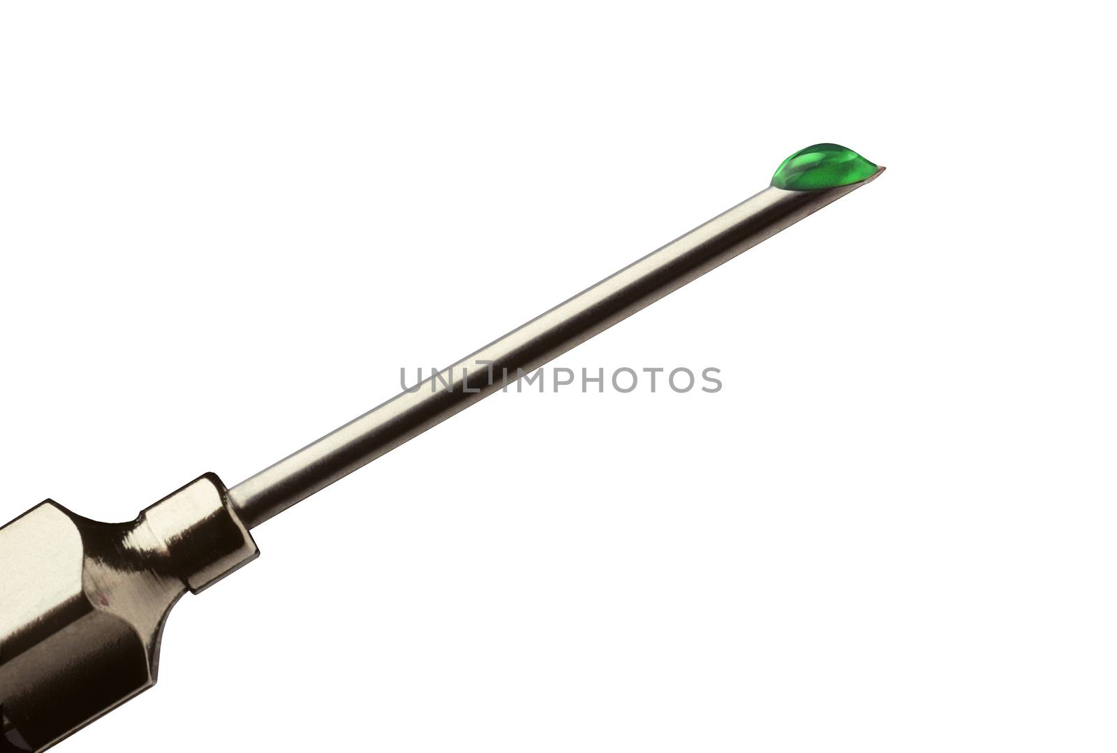 Closeup of a drop of green liquid at the tip of a hypodermic needle against a white background