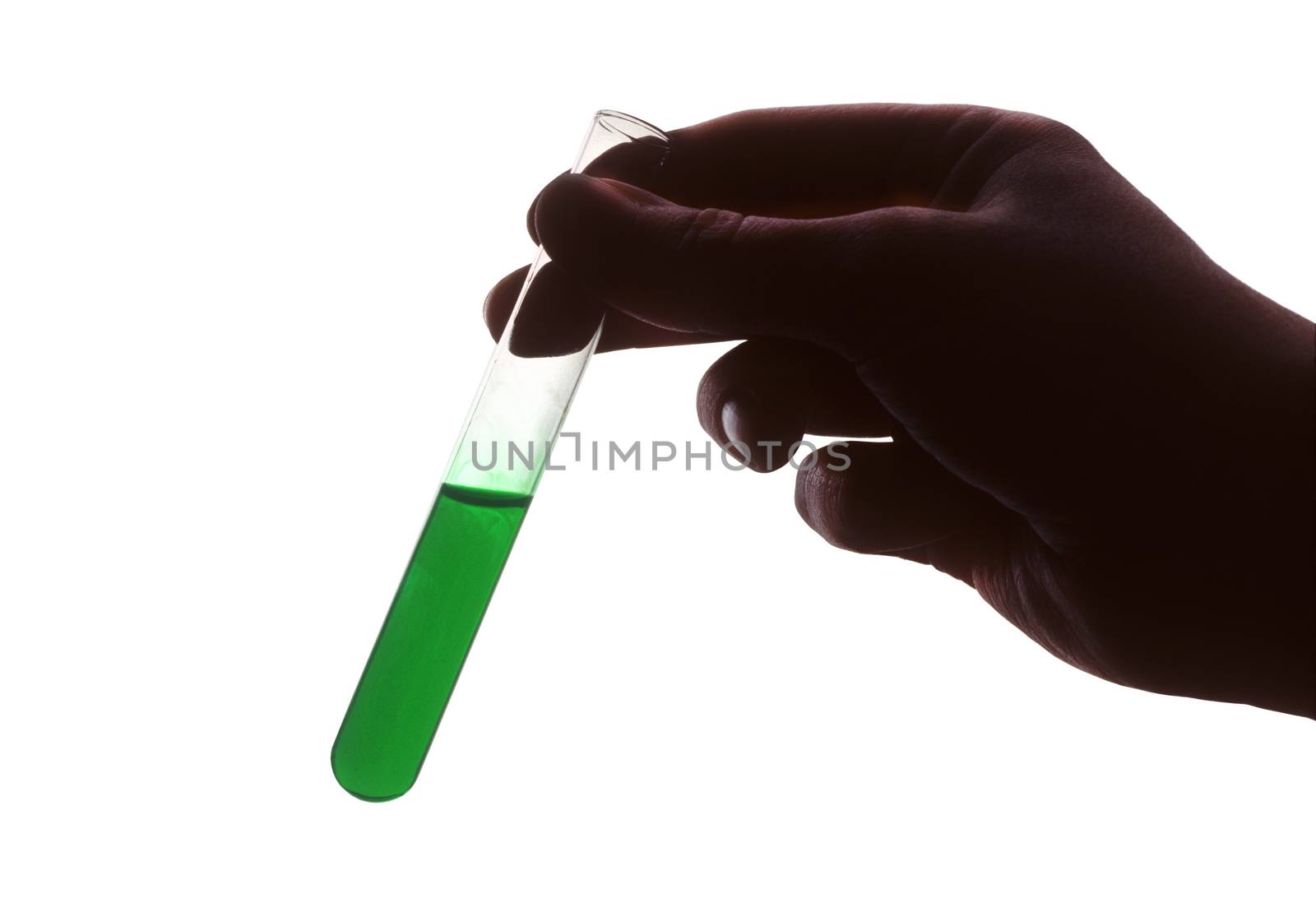 Hand holding test tube of green liquid against white background