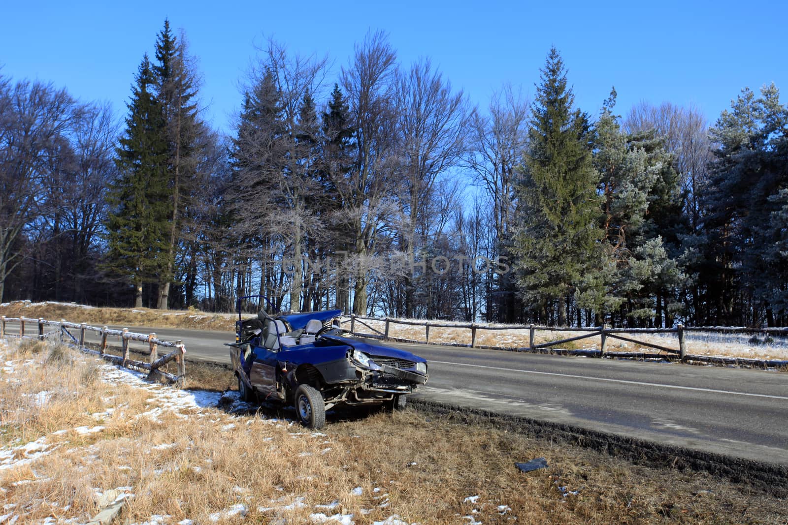 Front of blue car damaged by crash accident on side of the road