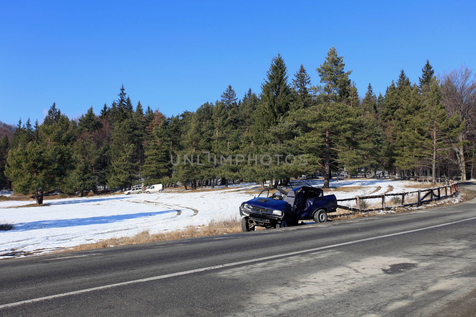 Front of blue car damaged by crash accident on side of the road