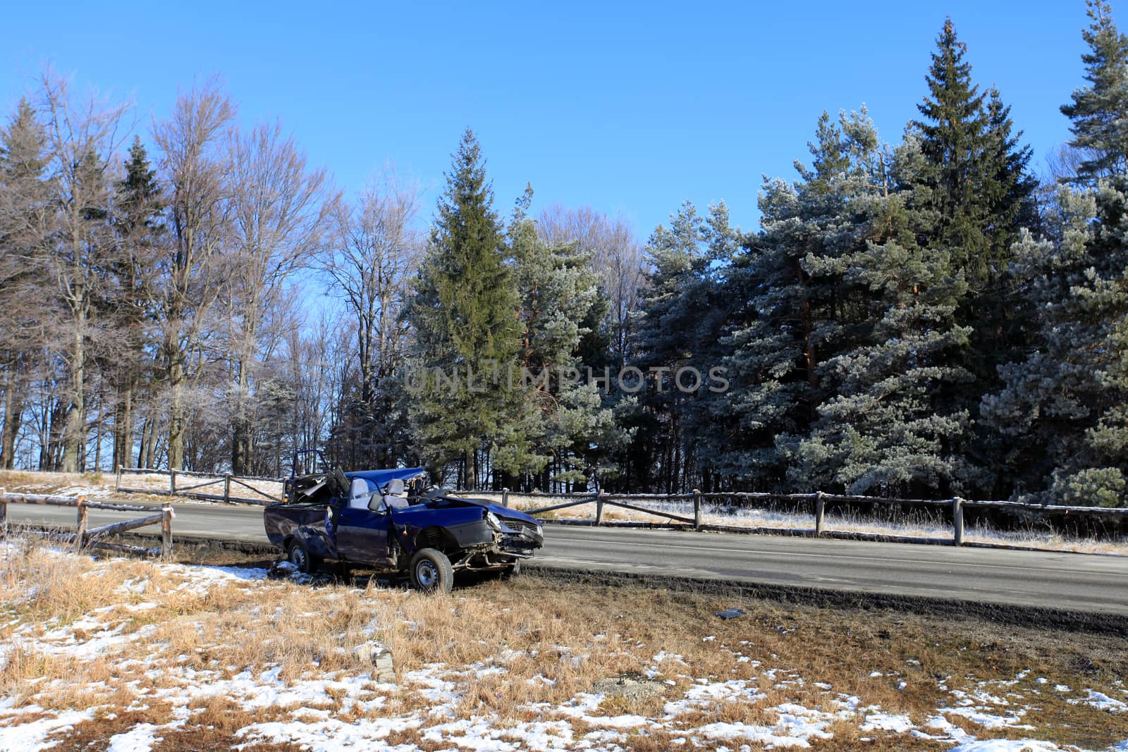 Blue car damaged by crash accident on side of the road