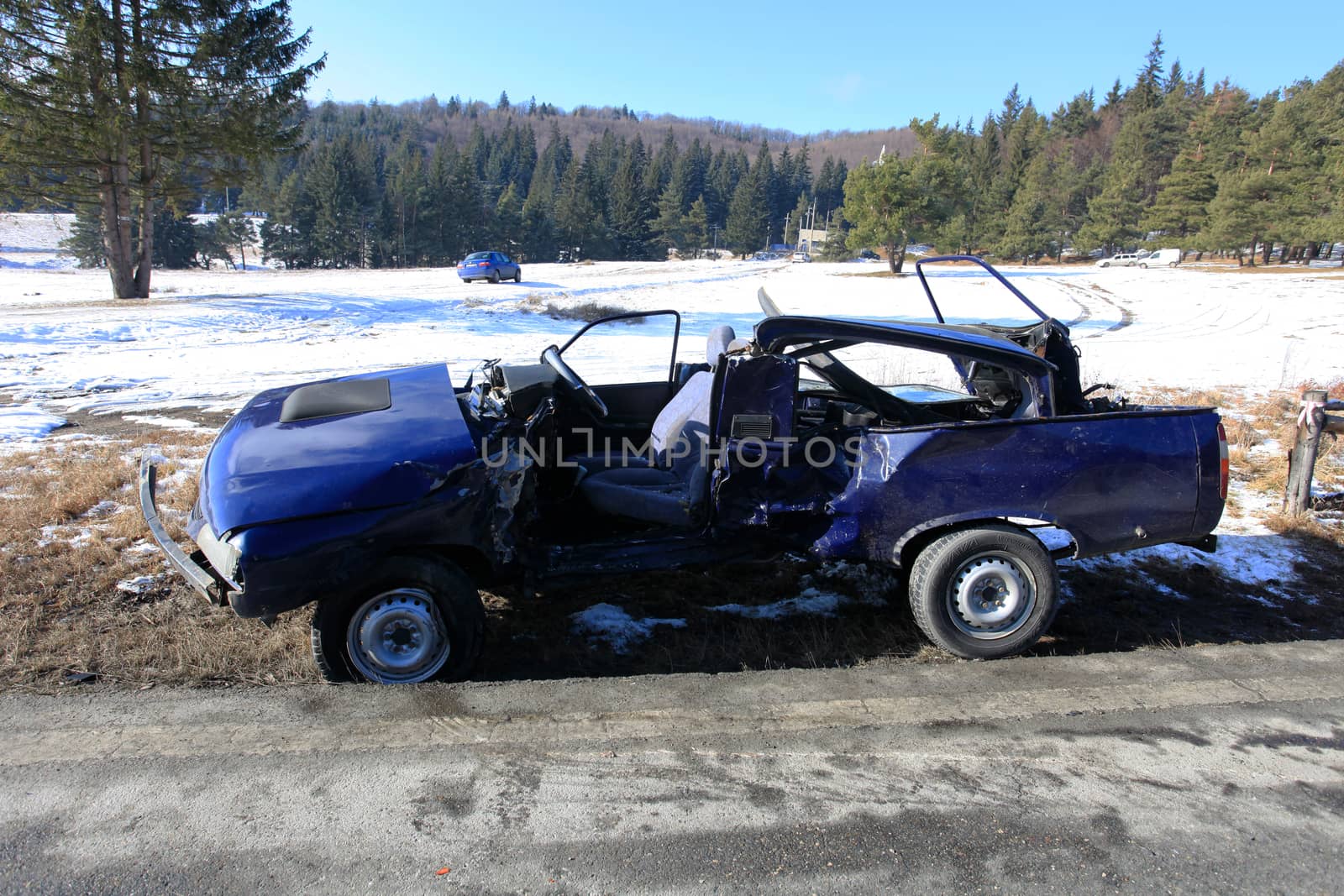 Front of blue car damaged by crash accident on side of the road by PixAchi