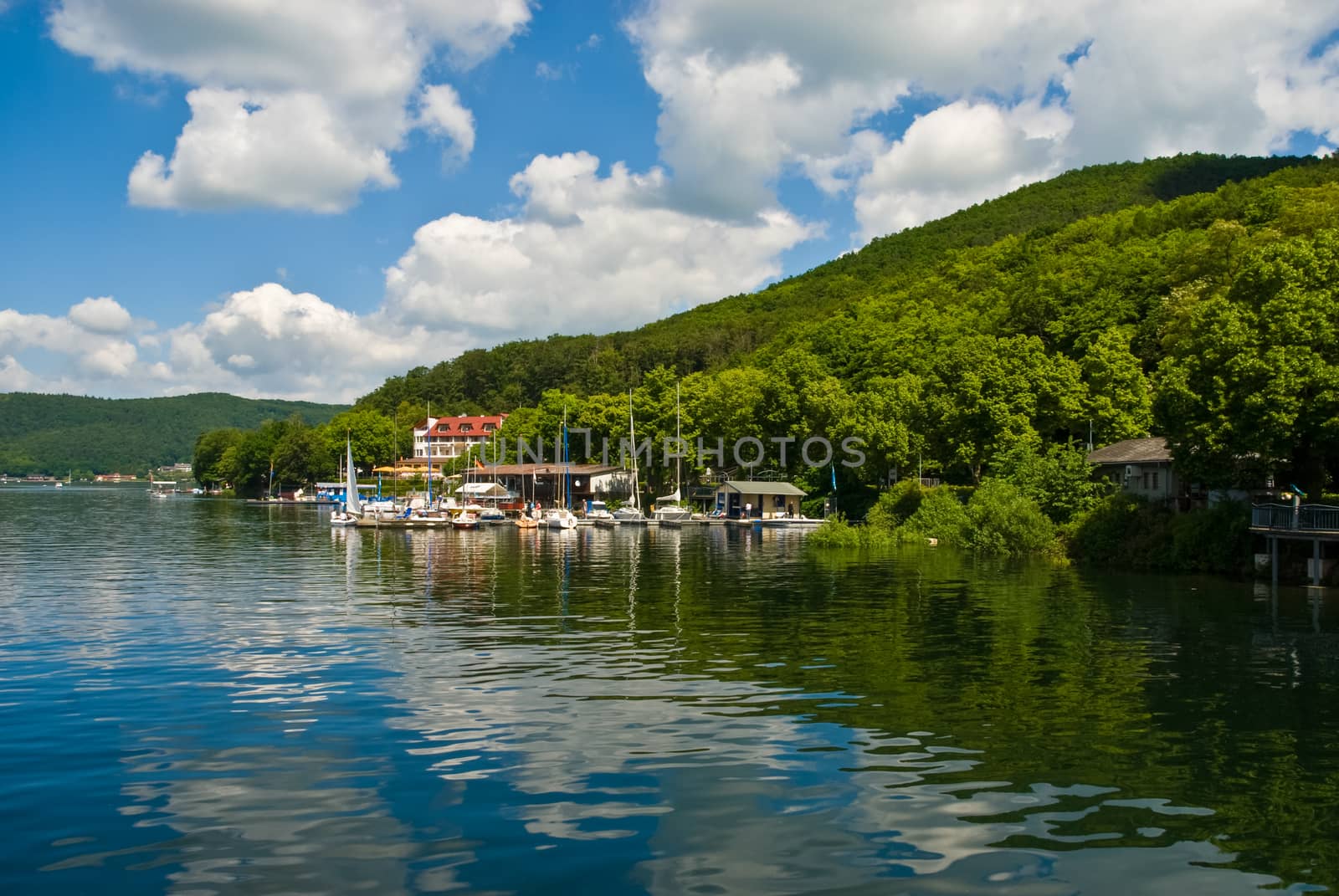 Sky and hills reflecting in sea in summer near near harbor by MXW_Stock