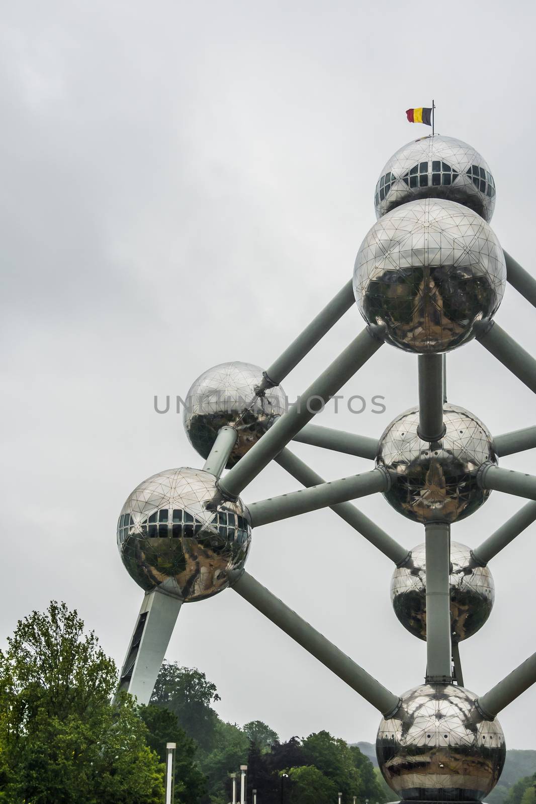 The Atomium in Brussels with Belgium flag on roof by MXW_Stock