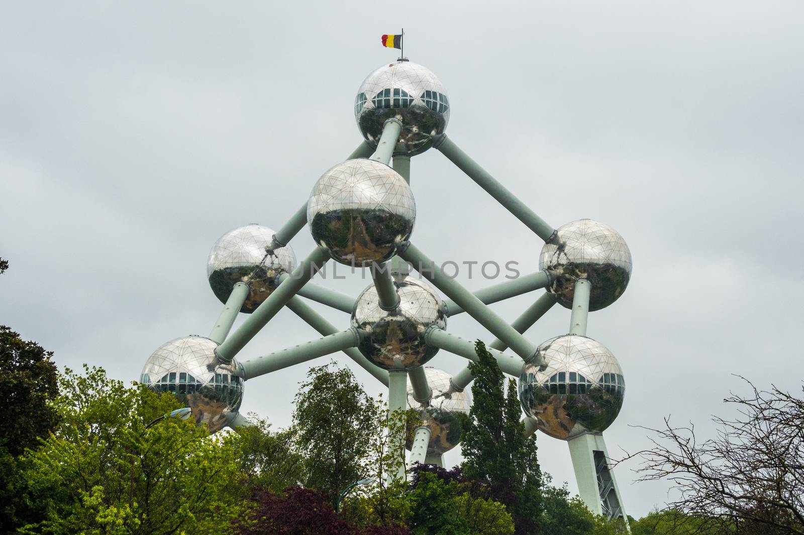 The Atomium in Brussels at bad weather with flag on roof by MXW_Stock
