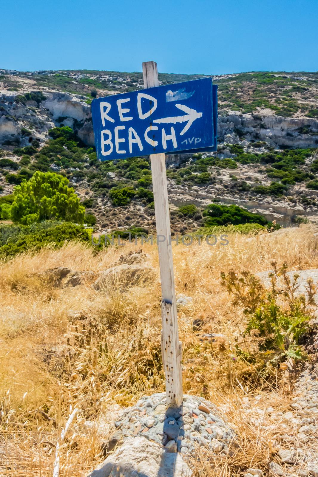 Wood sign showing the direction to a beach on hiking path