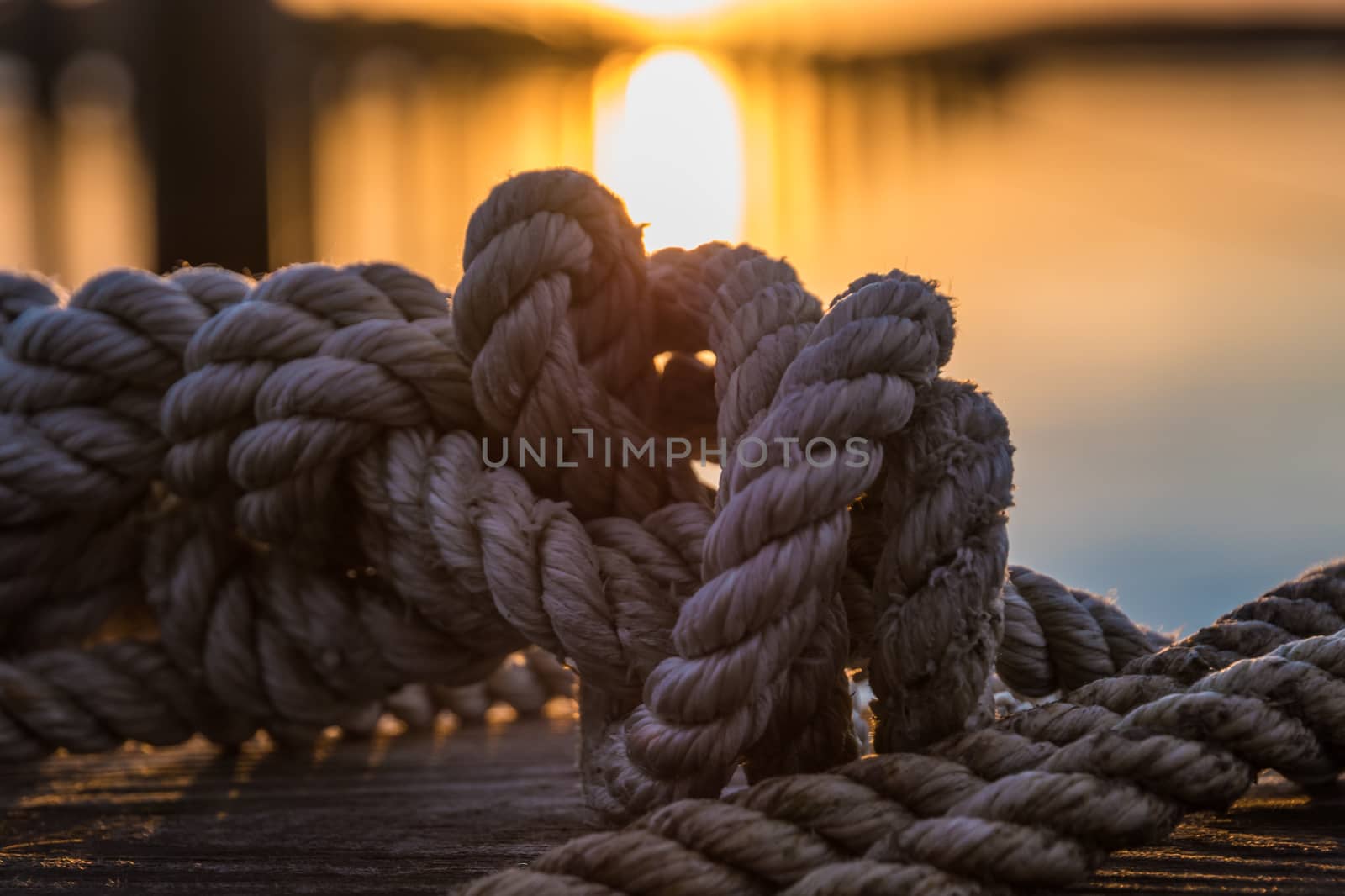 Orange and yellow sky above harbor port sunset rope by MXW_Stock