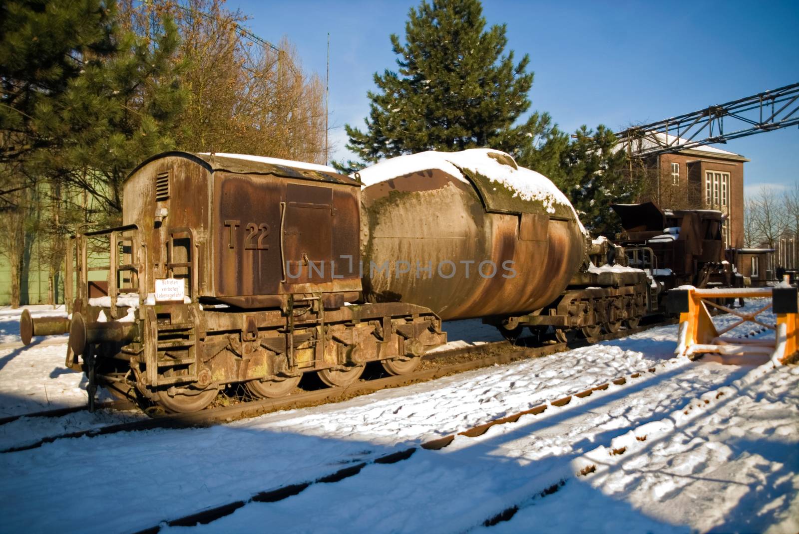 Industrial plant torpedo car train rail in winter snow ice steel rust
