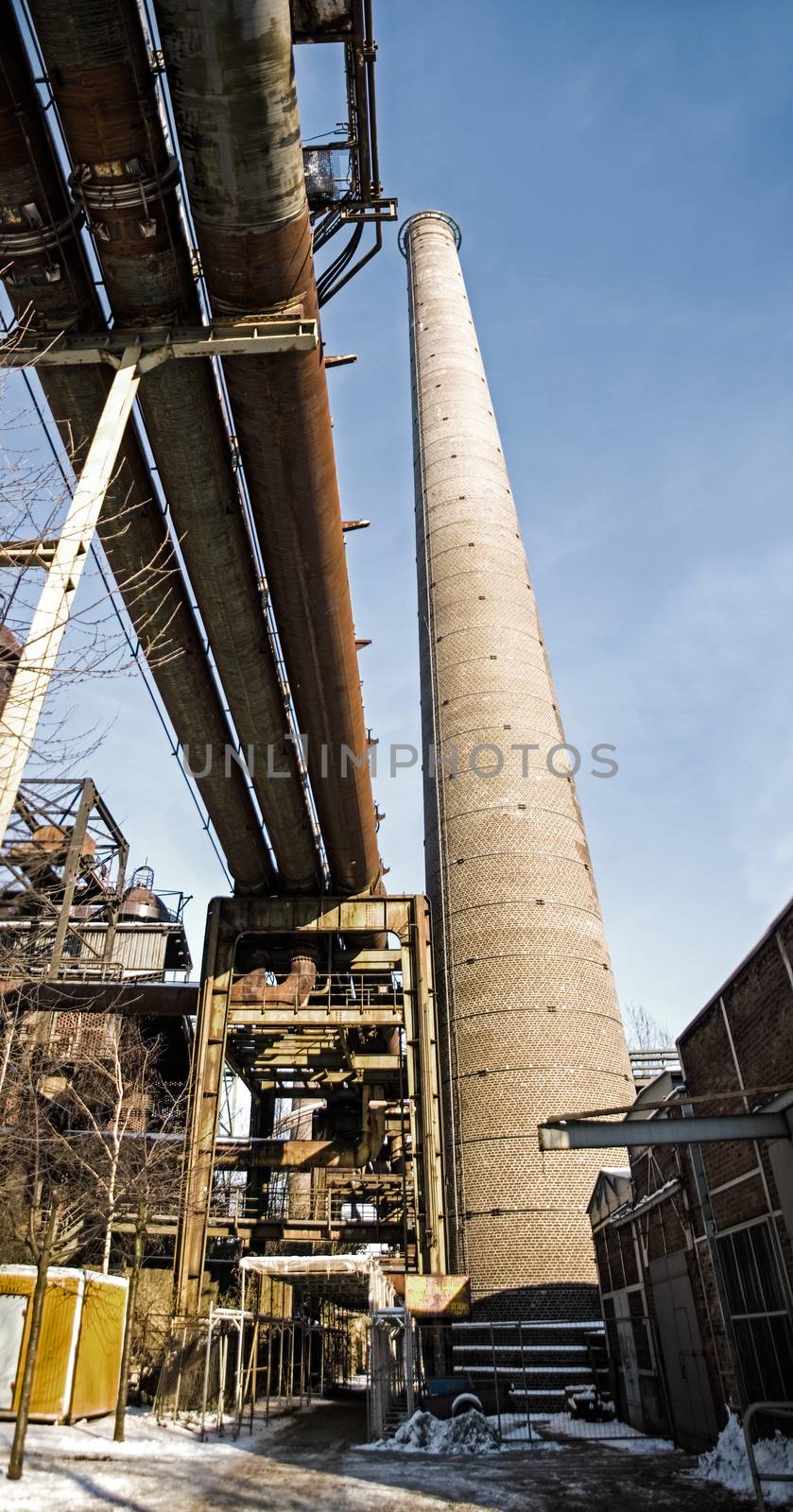 Panorama of industrial plant pipeline chimney in winter snow ice by MXW_Stock