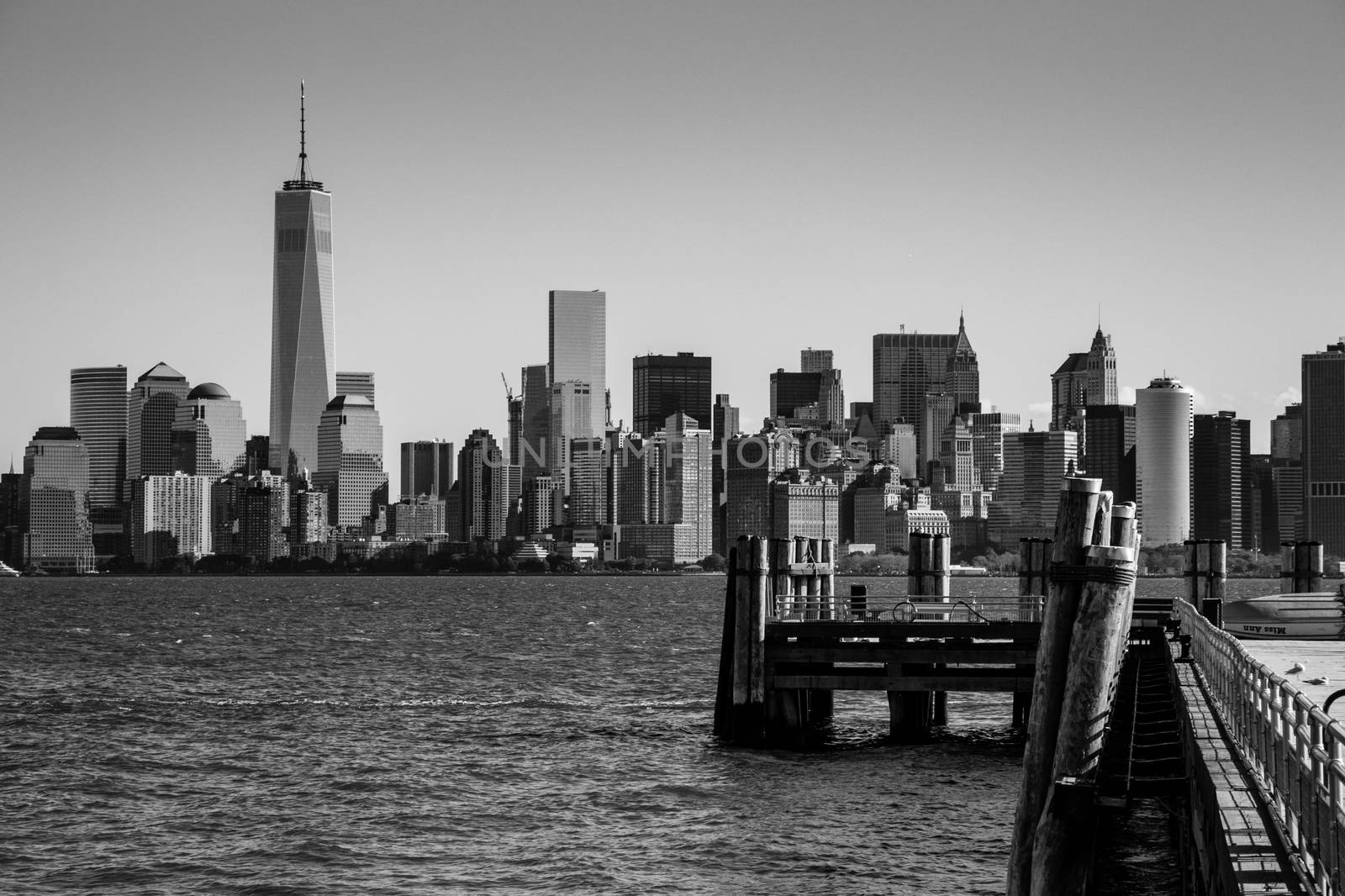 Landing pier at Liberty Island in front of New York skyline Blac by MXW_Stock