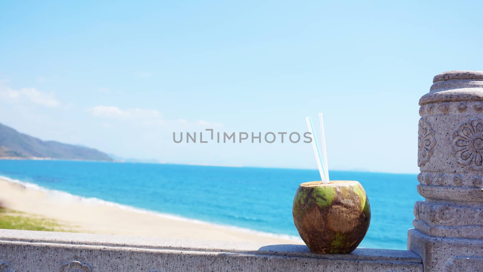 Coconut water drink on a tropical beach. Sea Beach in the background