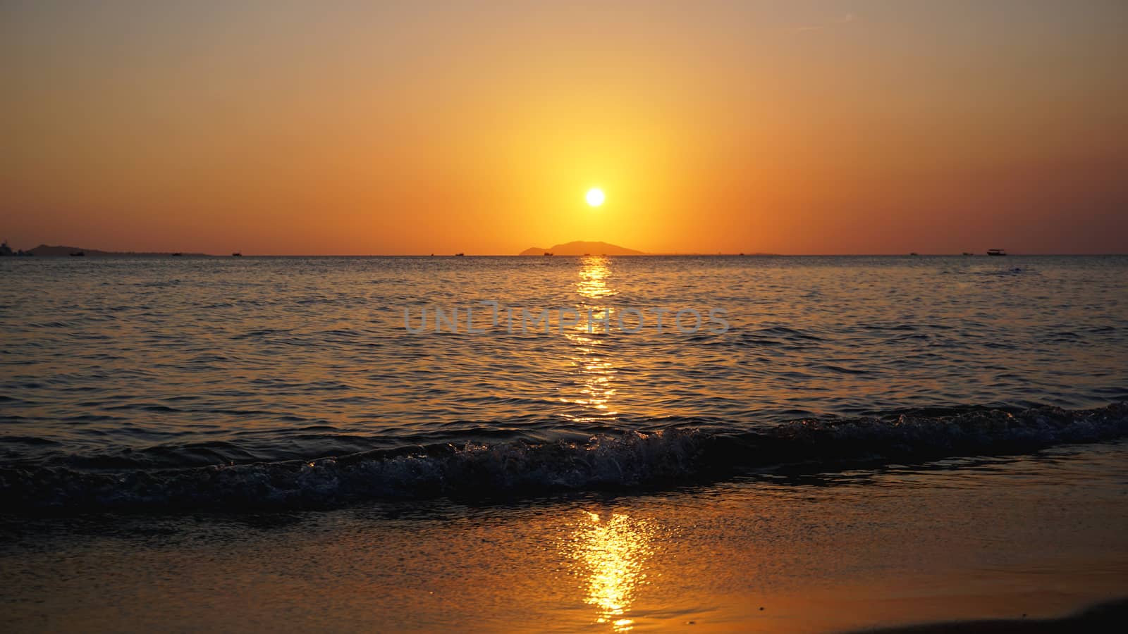 Bright sunset with yellow sun under the sea surface - Summer vacation and nature travel adventure concept.