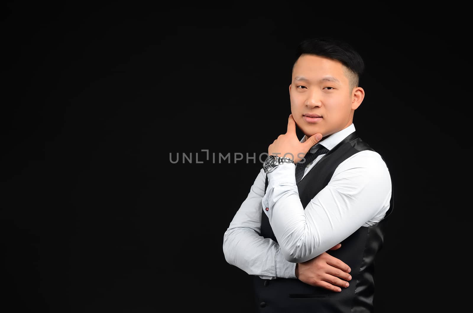 Asian young man looks at the camera, put his hand to face, turned sideways