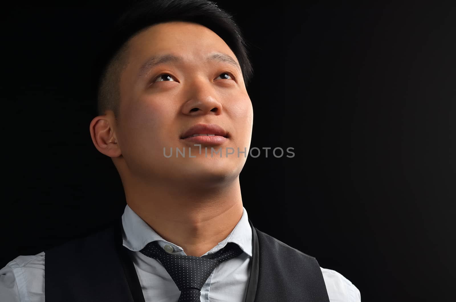 Portrait of an Asian young man looking up, dressed in a shirt, smiling