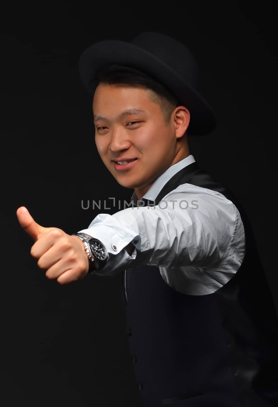 Young Asian man in shirt and jacket shows gesture "super" on camera