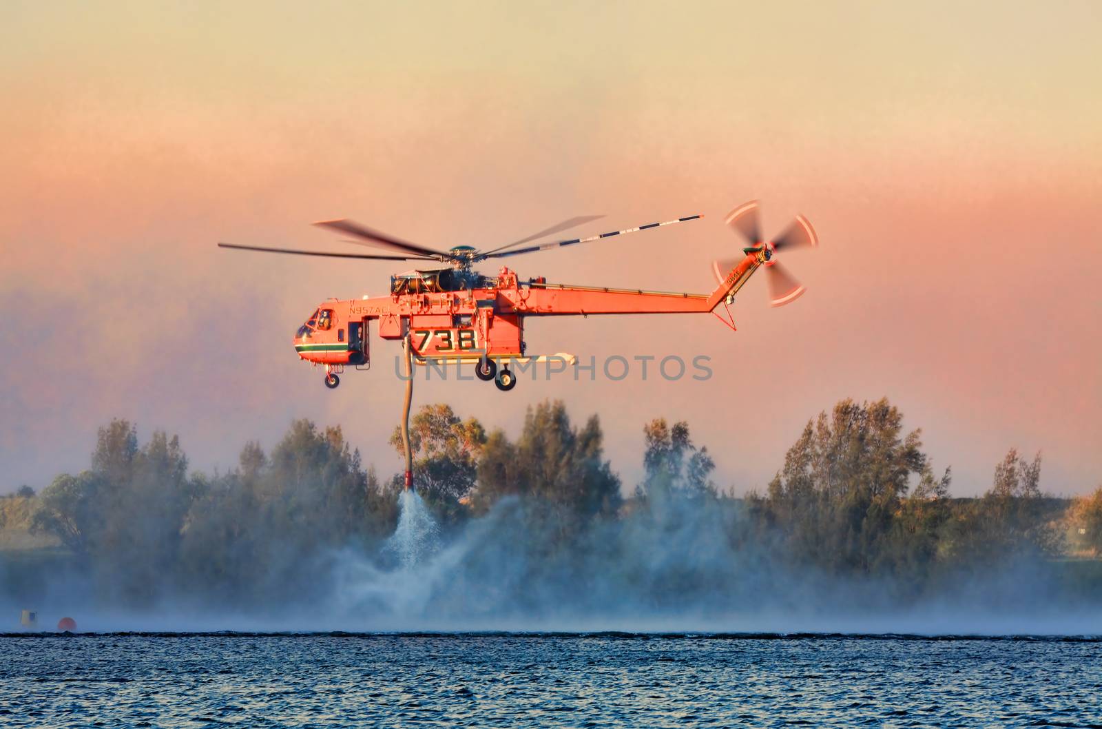 Penrith, Australia - October 23, 2013:  NSW Rural Fire Service using the Sikorsky Erickson Air-Crane to fight  large bush fires and protect property in difficult terrain in the Blue Mountains.  Dense heavy smoke fills the air. 