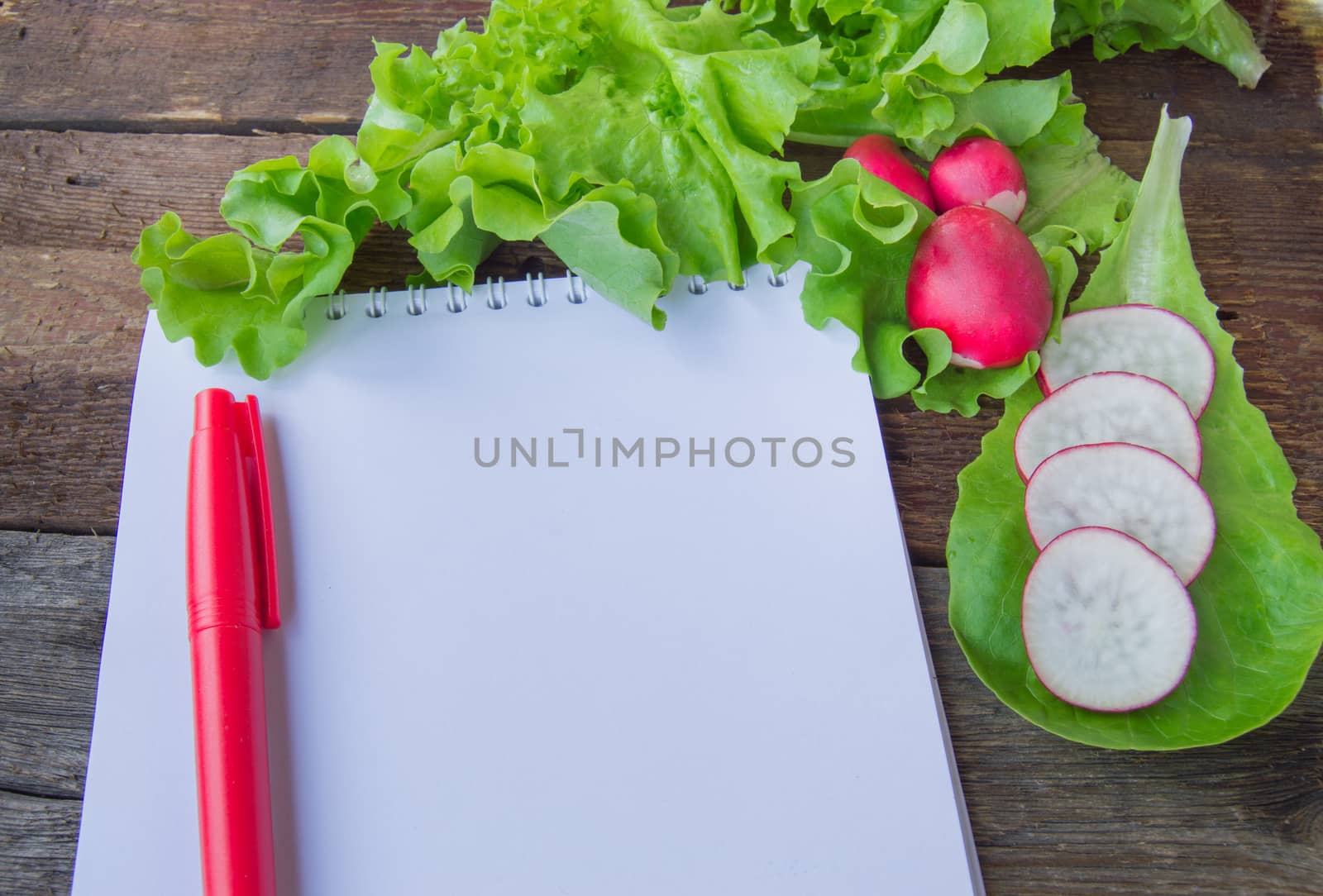 The concept of healthy eating, diet, lettuce, radishes, pen Notepad copy space