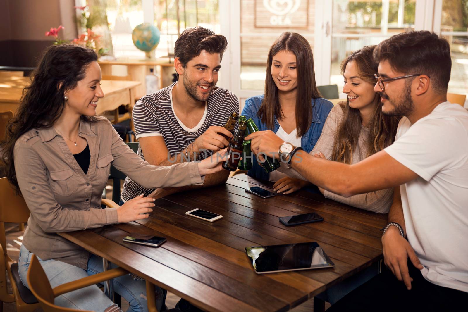 Group of friends hanging out and making a toast with beer 