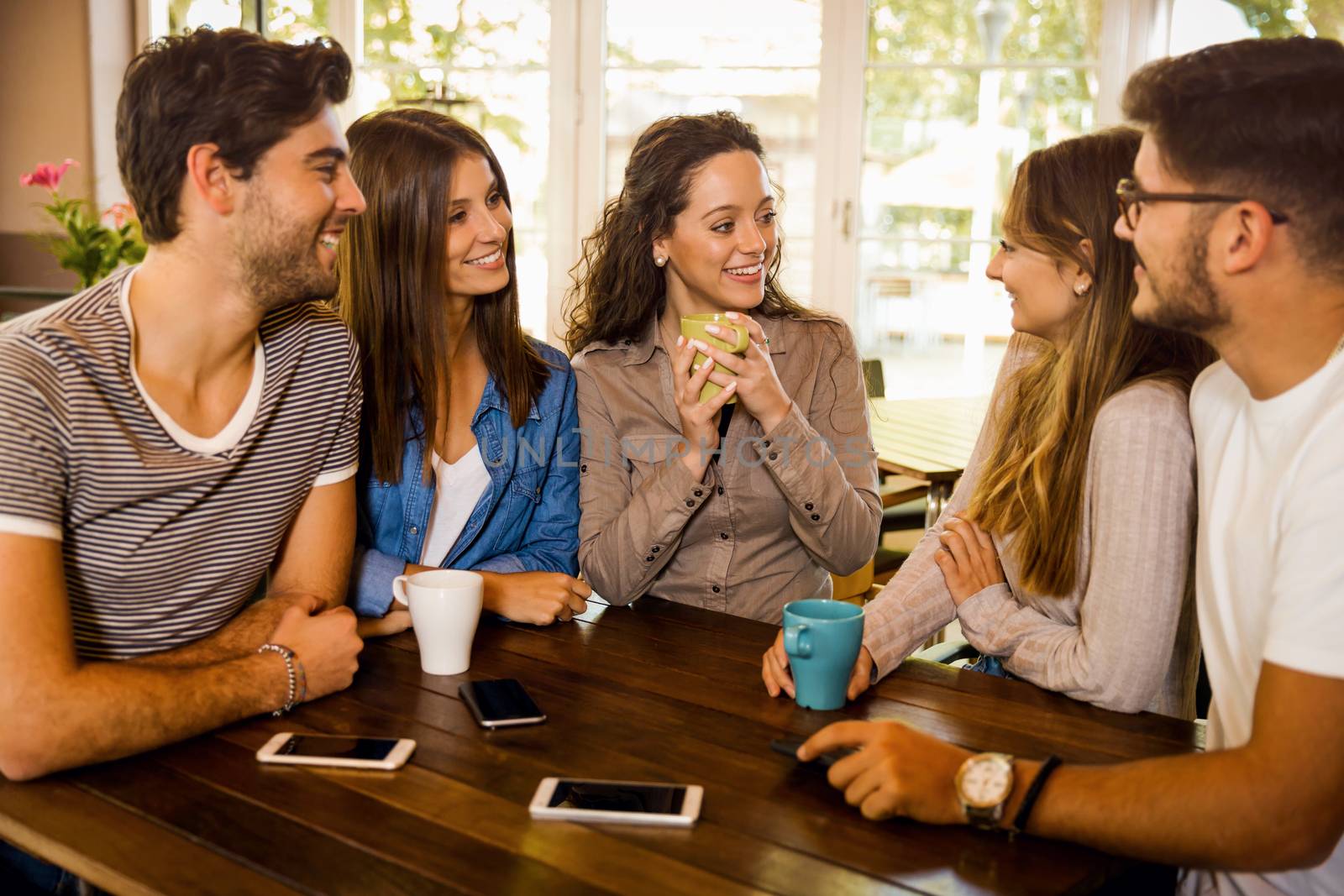 A group of friends talking and drinking coffee at the cafe