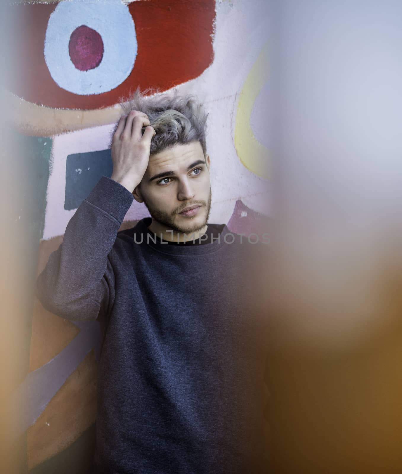 One handsome young man in urban setting in European city, standing