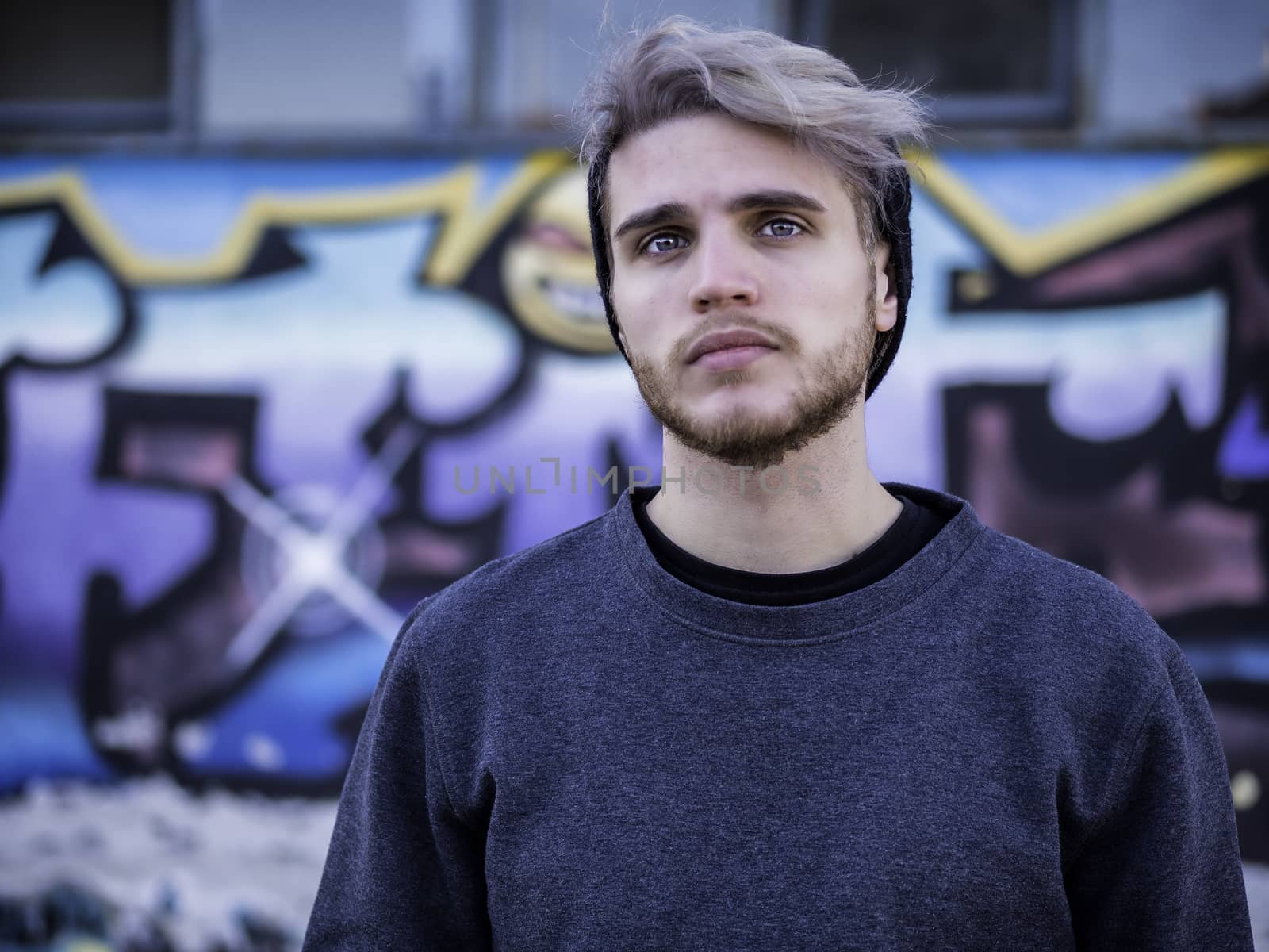 One handsome young man in urban setting in European city, standing