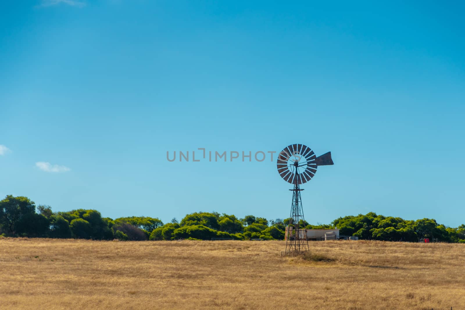 Old rusty windmill on dry farmland Western Australia by MXW_Stock