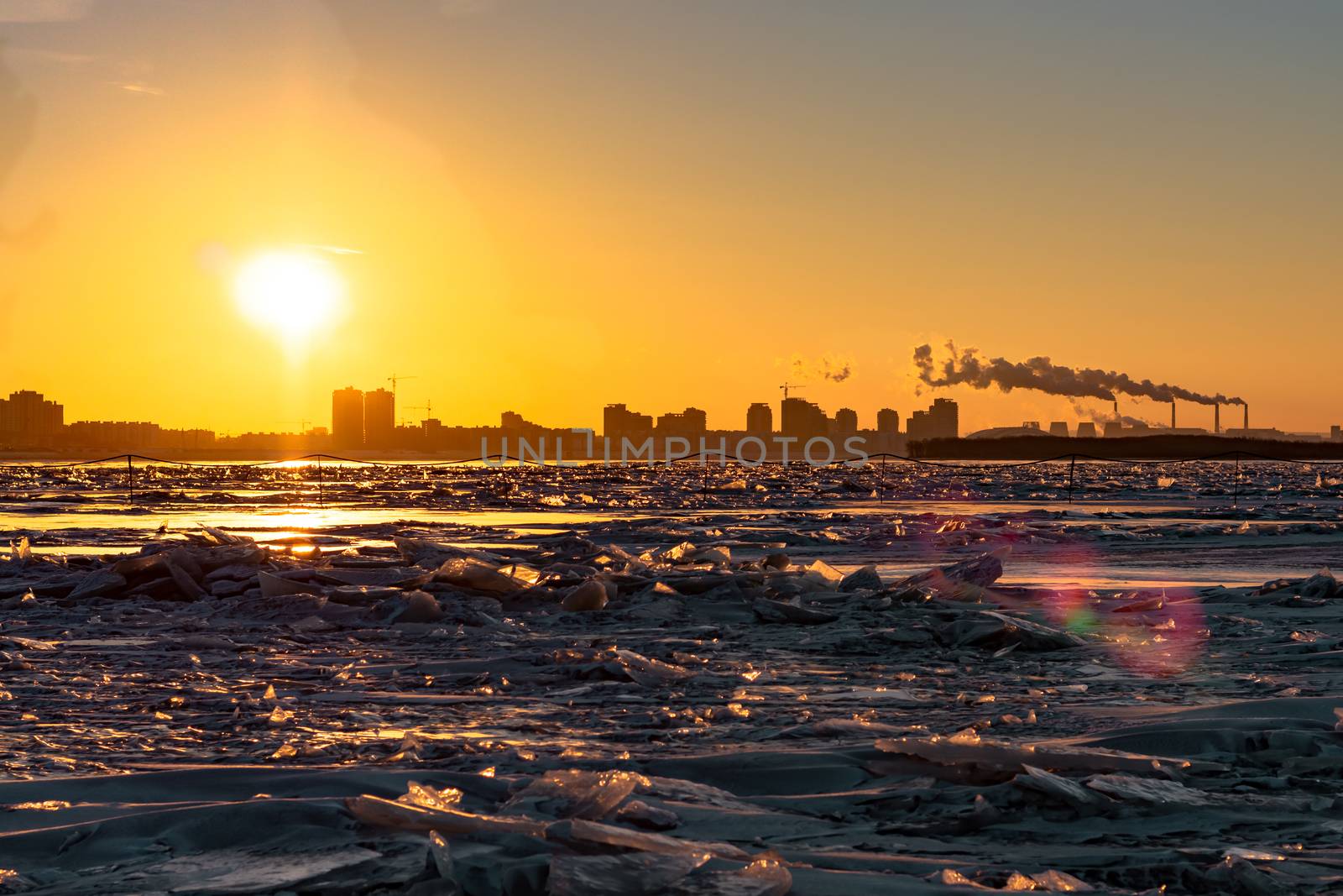 View of the city of Khabarovsk from the middle of the frozen Amur river. Factories on the horizon.