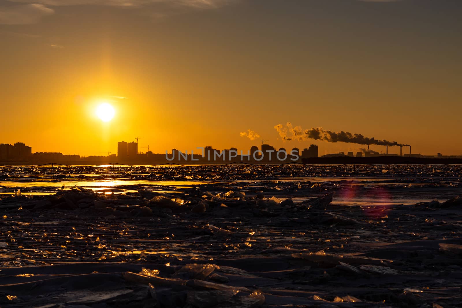 View of the city of Khabarovsk from the middle of the frozen Amur river. Factories on the horizon.