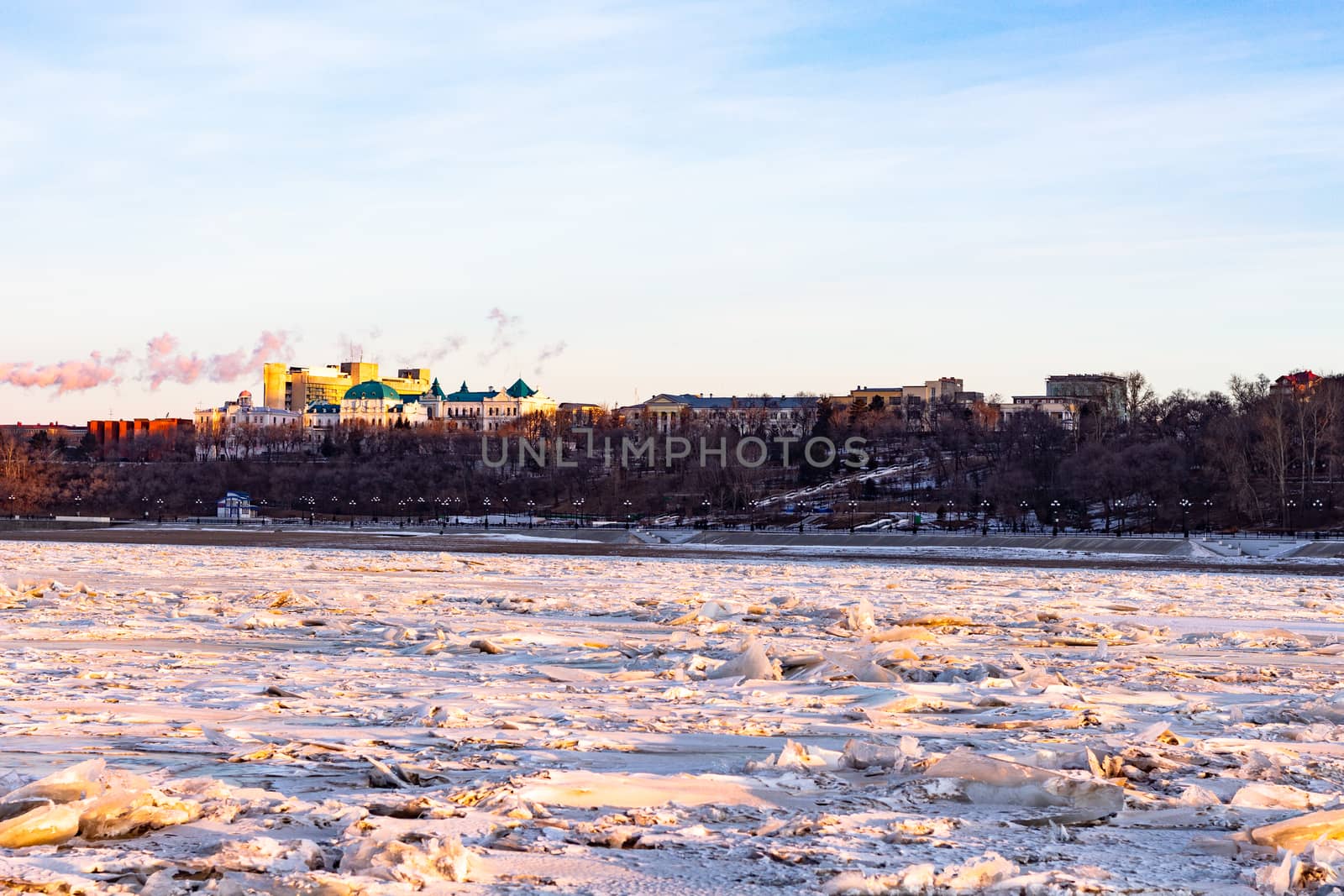 View of the city of Khabarovsk from the middle of the frozen Amur river. Factories on the horizon.