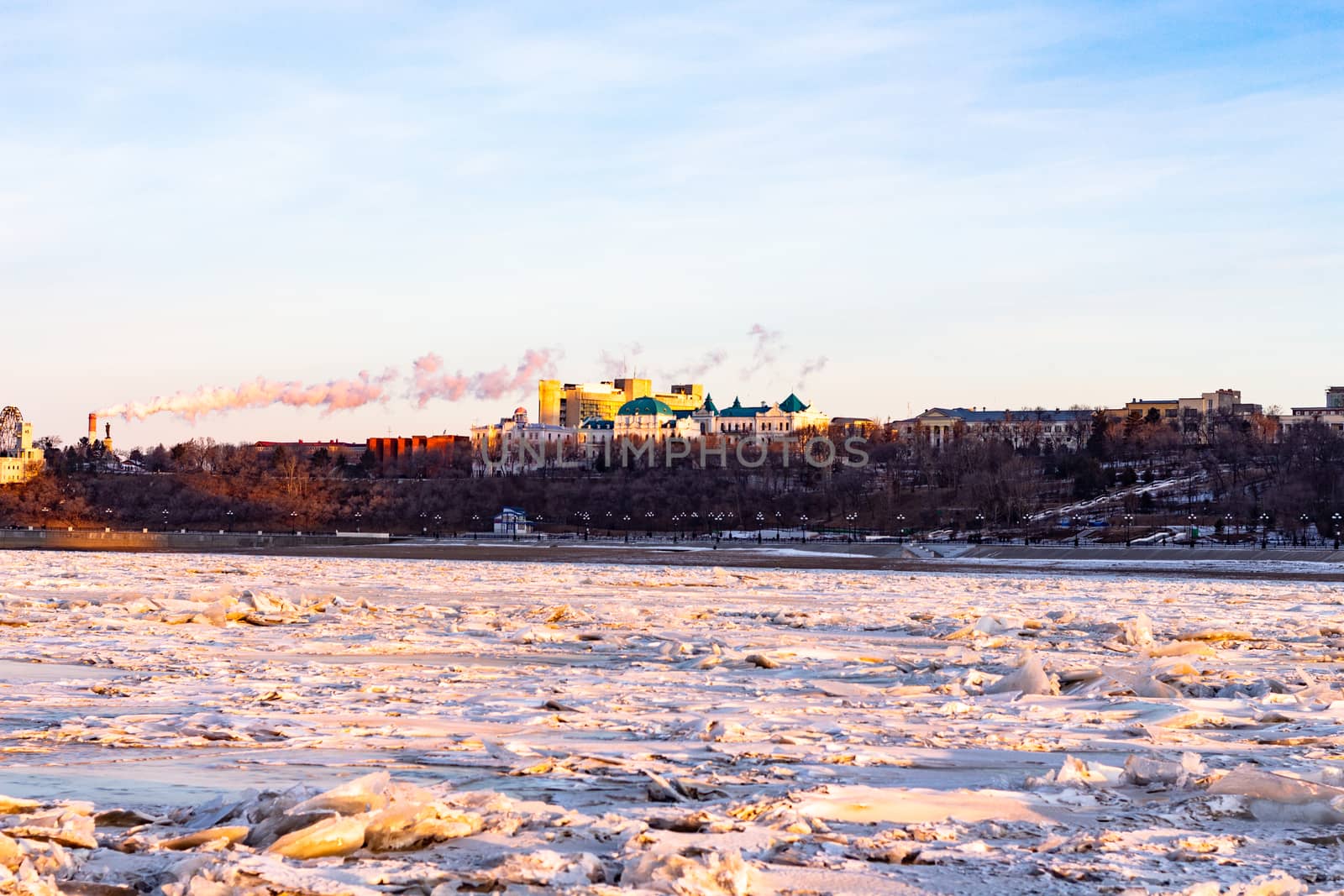 View of the city of Khabarovsk from the middle of the frozen Amur river. Factories on the horizon.