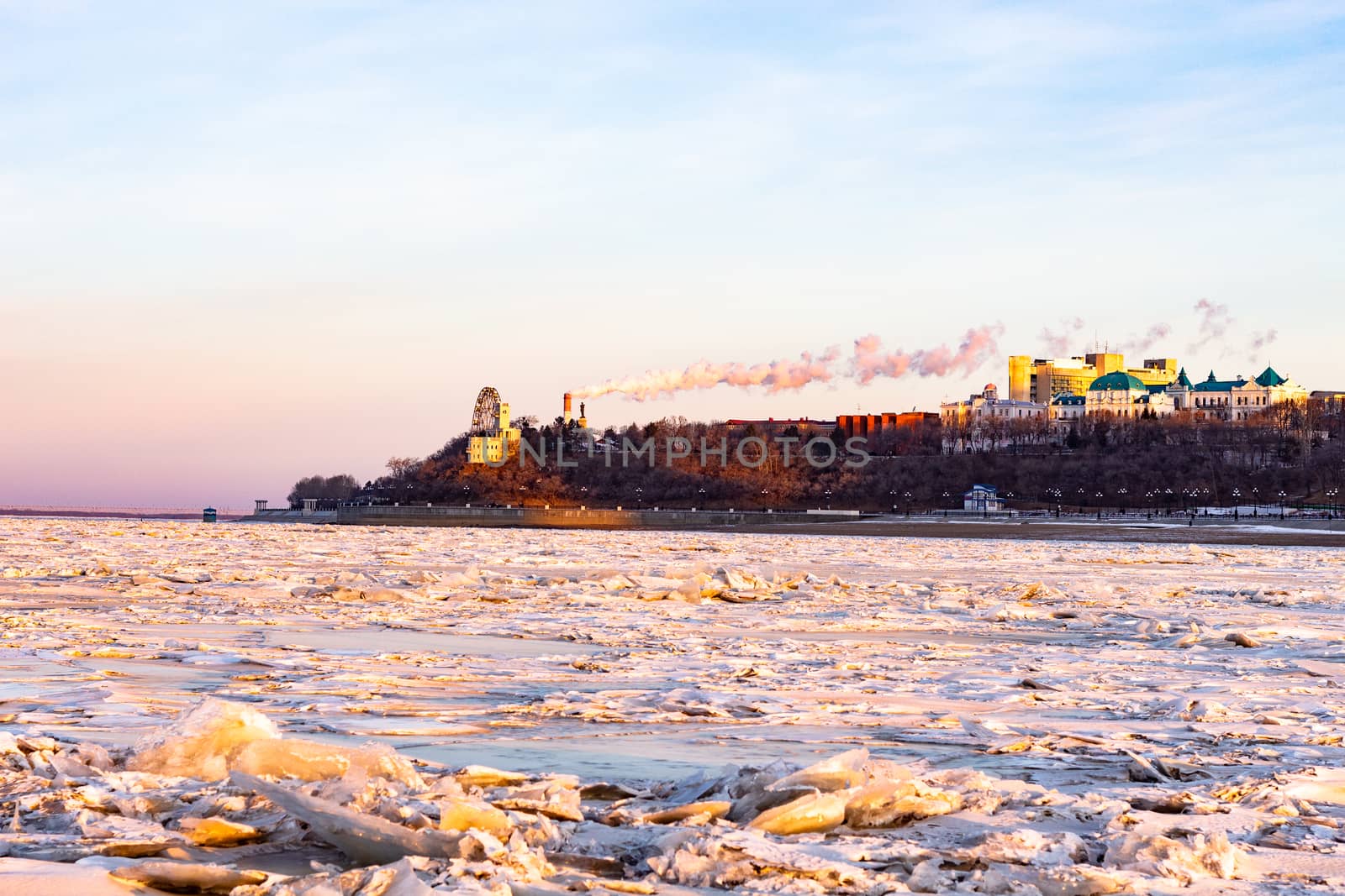 View of the city of Khabarovsk from the middle of the frozen Amur river. Factories on the horizon.