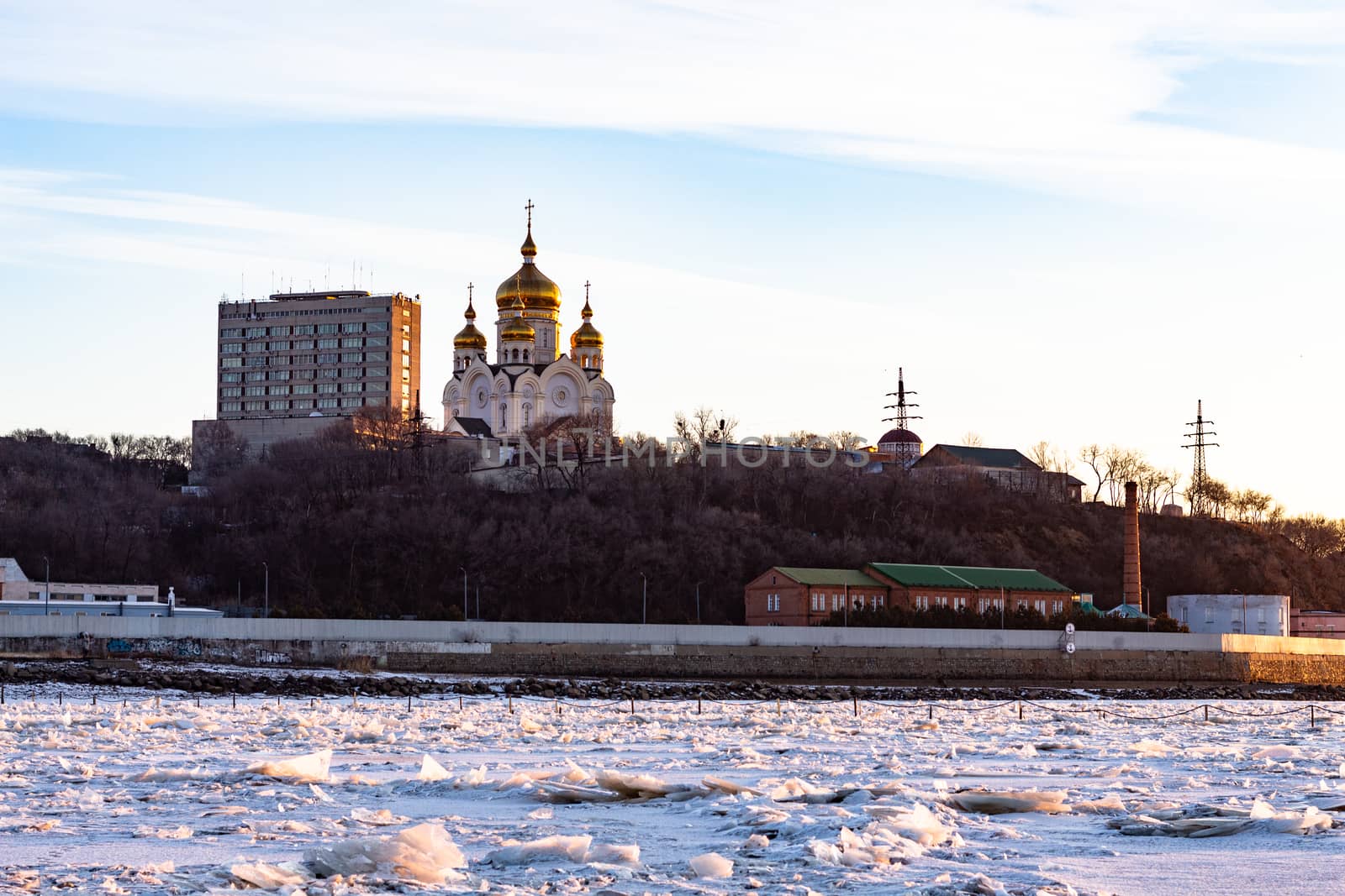 View of the city of Khabarovsk from the middle of the frozen Amur river. Factories on the horizon.