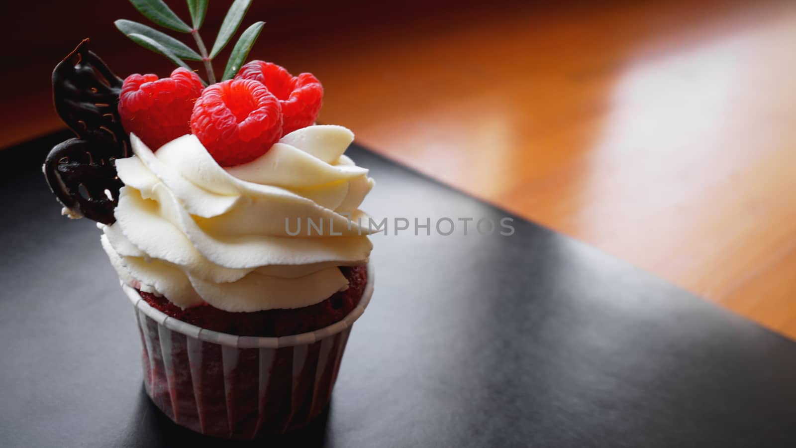 Delicious raspberry cupcakes on dark background - Handmade Sweet dessert, cupcake with butter cream and raspberry