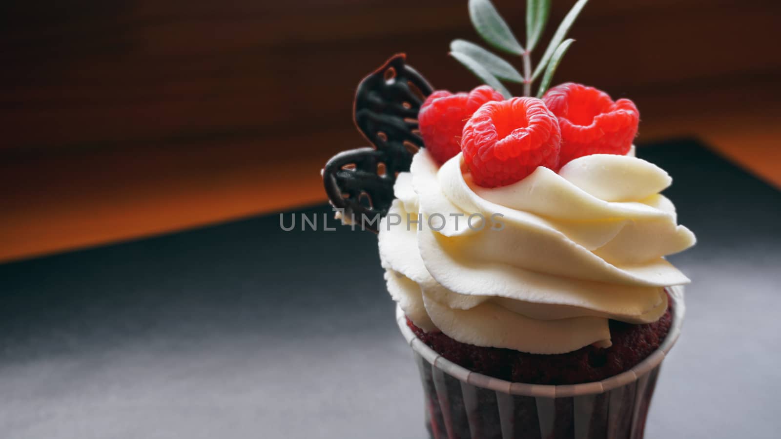 Delicious raspberry cupcakes on dark background - Handmade Sweet dessert, cupcake with butter cream and raspberry