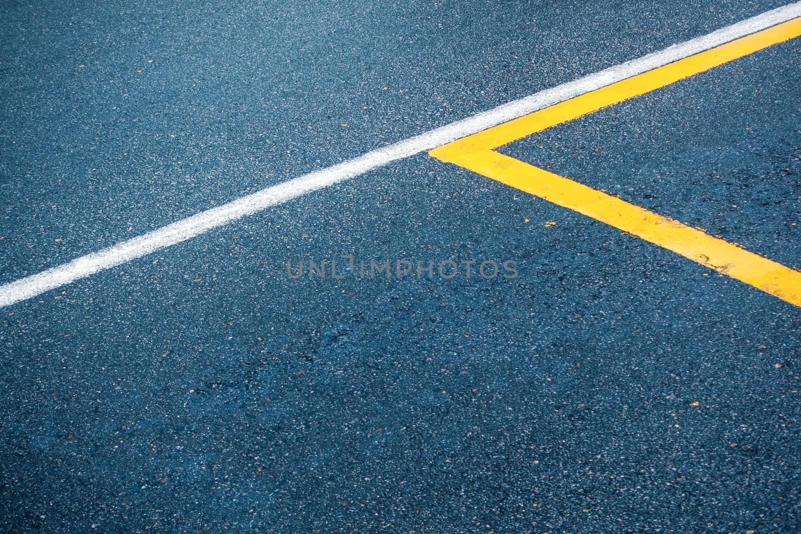 Asphalt road surface with white and yellow lines