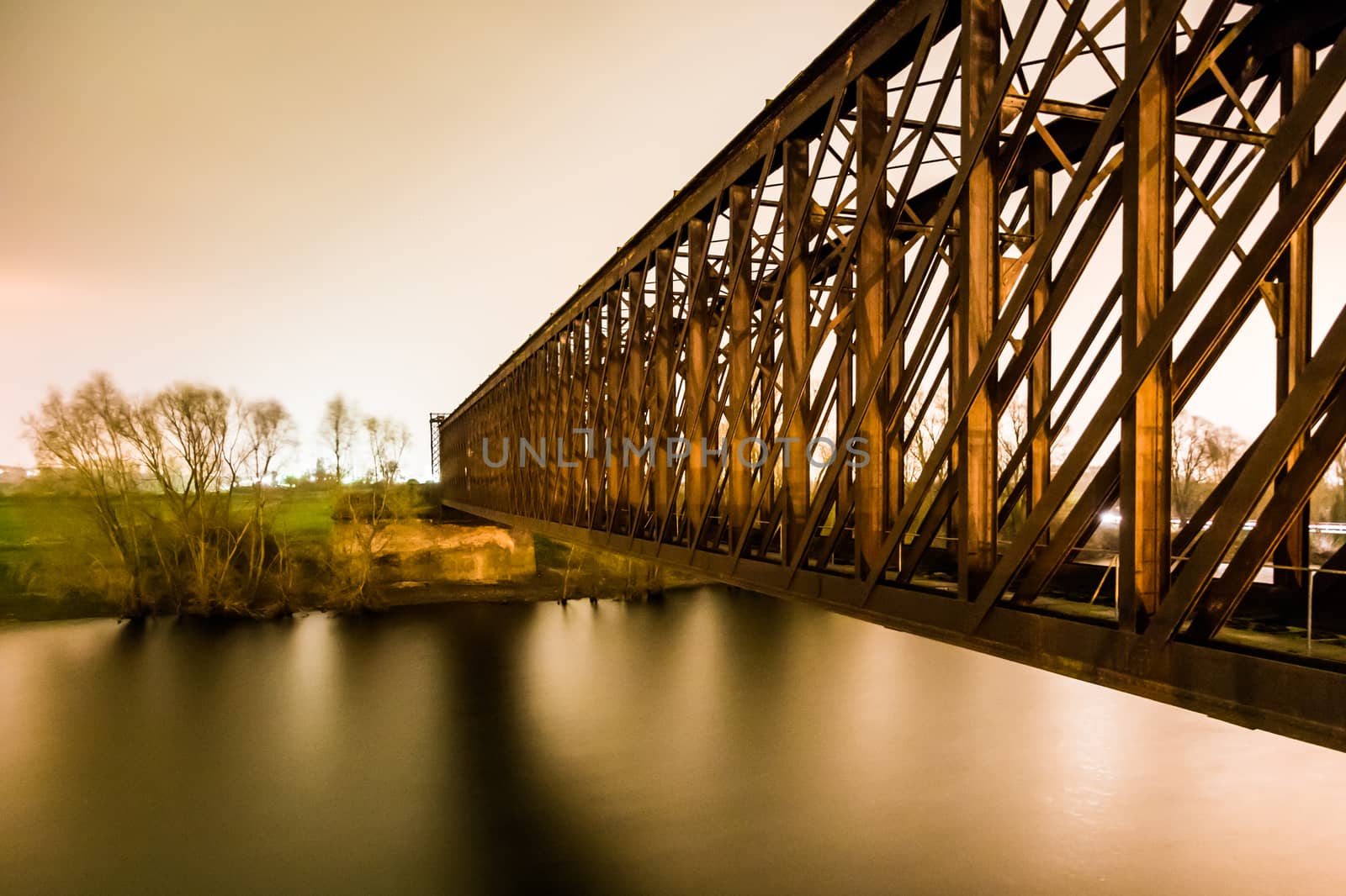 Old industrial railway railroad iron bridge in the night