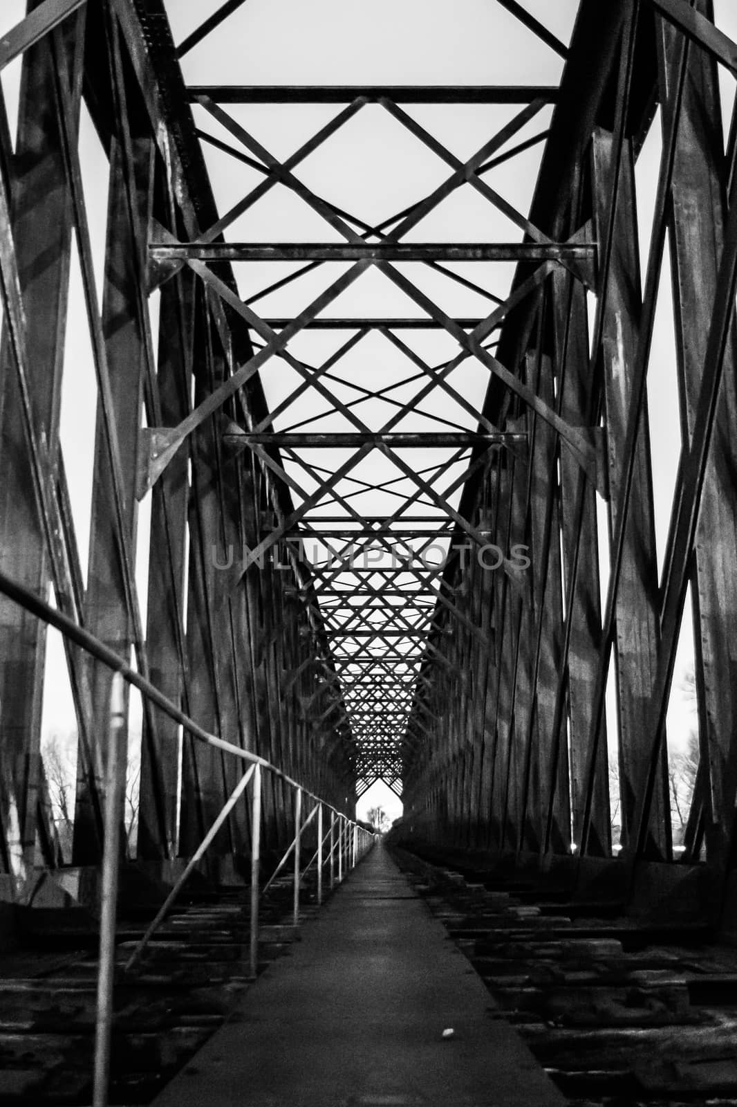 Black and white old industrial railway railroad iron bridge center perspective in night