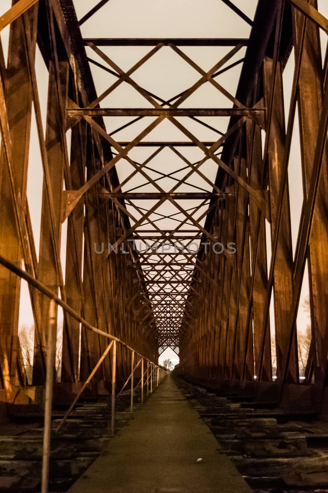 Old industrial railway railroad iron bridge center perspective in night