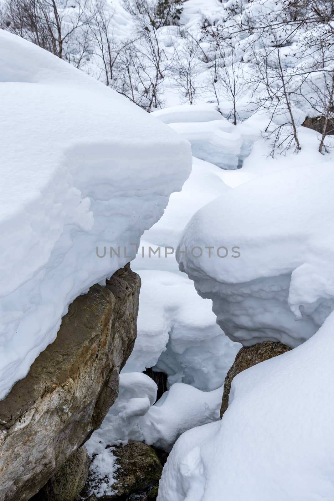 Deep snow on rocks hiking towards glacier by MXW_Stock